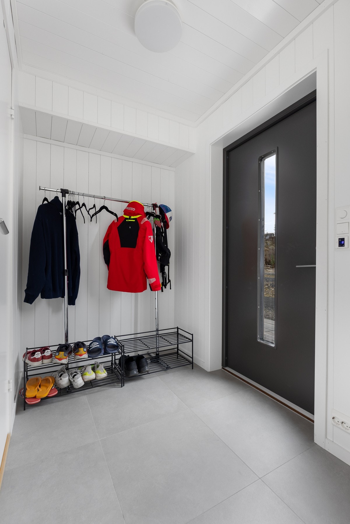 Fritidsboligen har en innbydende entre med flislagt gulv og hvitmalte panelvegger. Det er god plass til garderobeskap og skoskap. Galleribilde