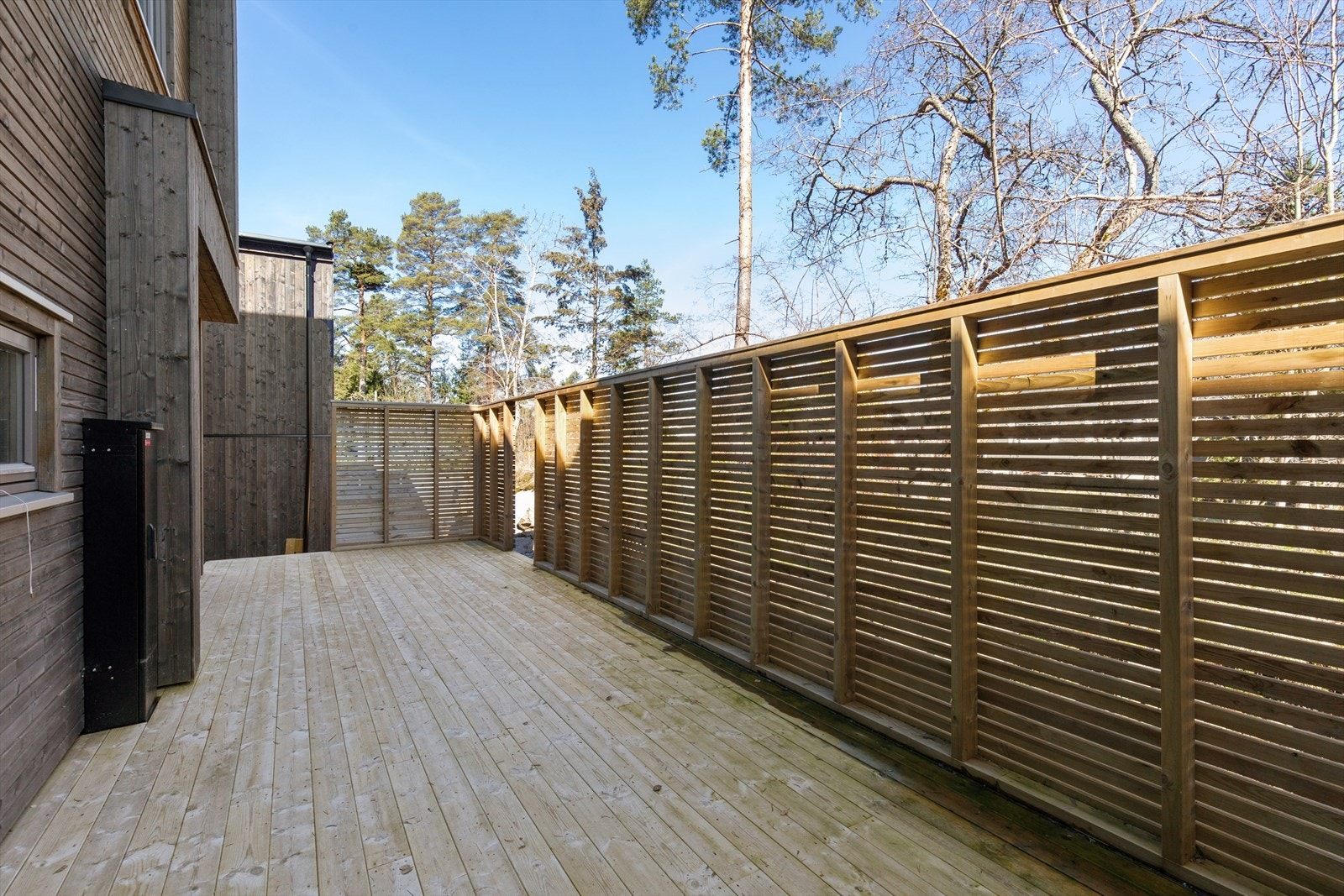 Stor terrasse på baksiden ved stuen med god plass til utemøbler og grill. Galleribilde