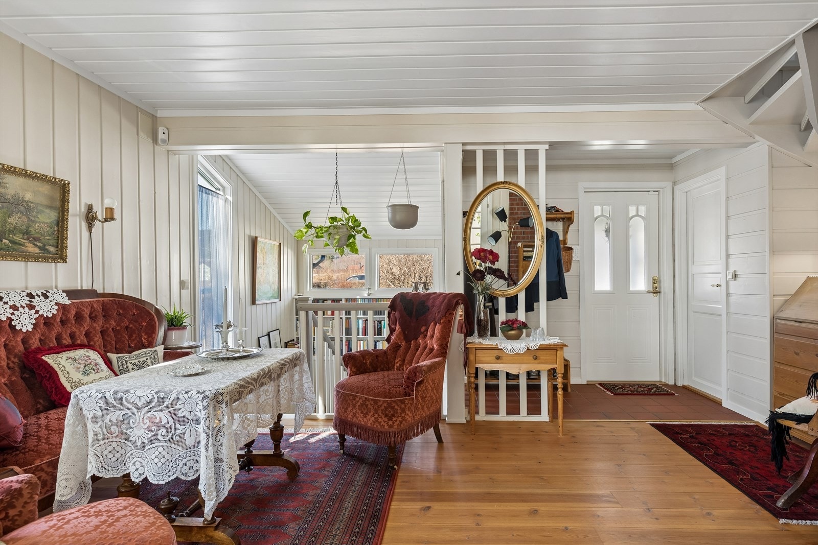 Velkommen inn! Hall/trapperom er romslig, og innredet med sofa gruppe og plassbygget bokhylle i trappegangen. Galleribilde