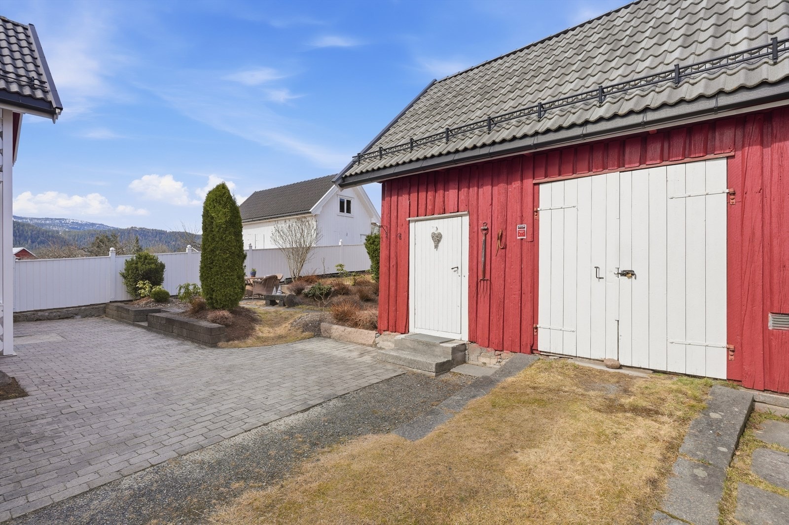 Uthuset har stående kledning og saltak med takstein, byttet i 2016. Galleribilde