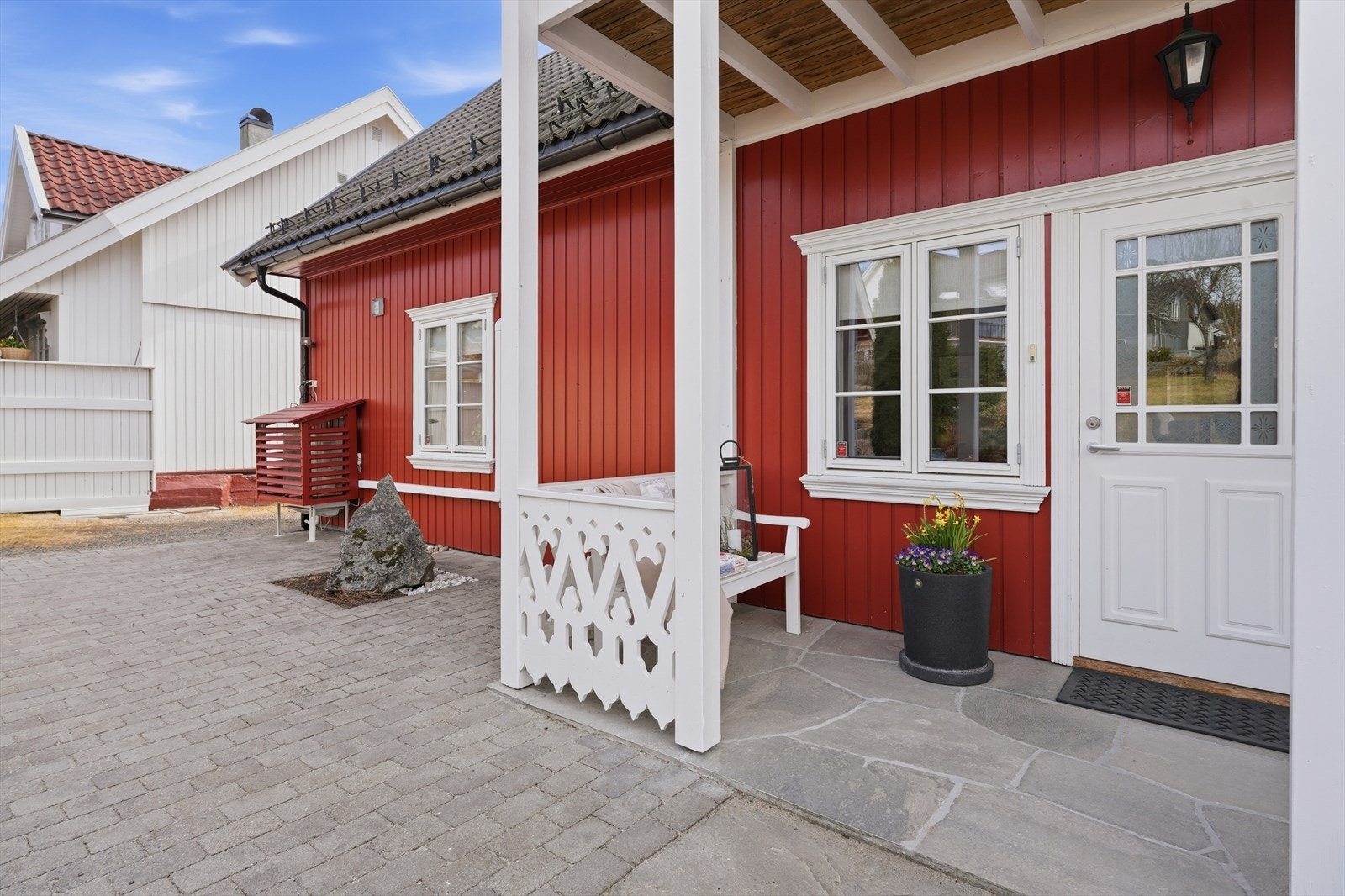 Et overbygget inngangsparti med belegningsstein og skiferheller, ønsker velkommen inn i boligen. Galleribilde