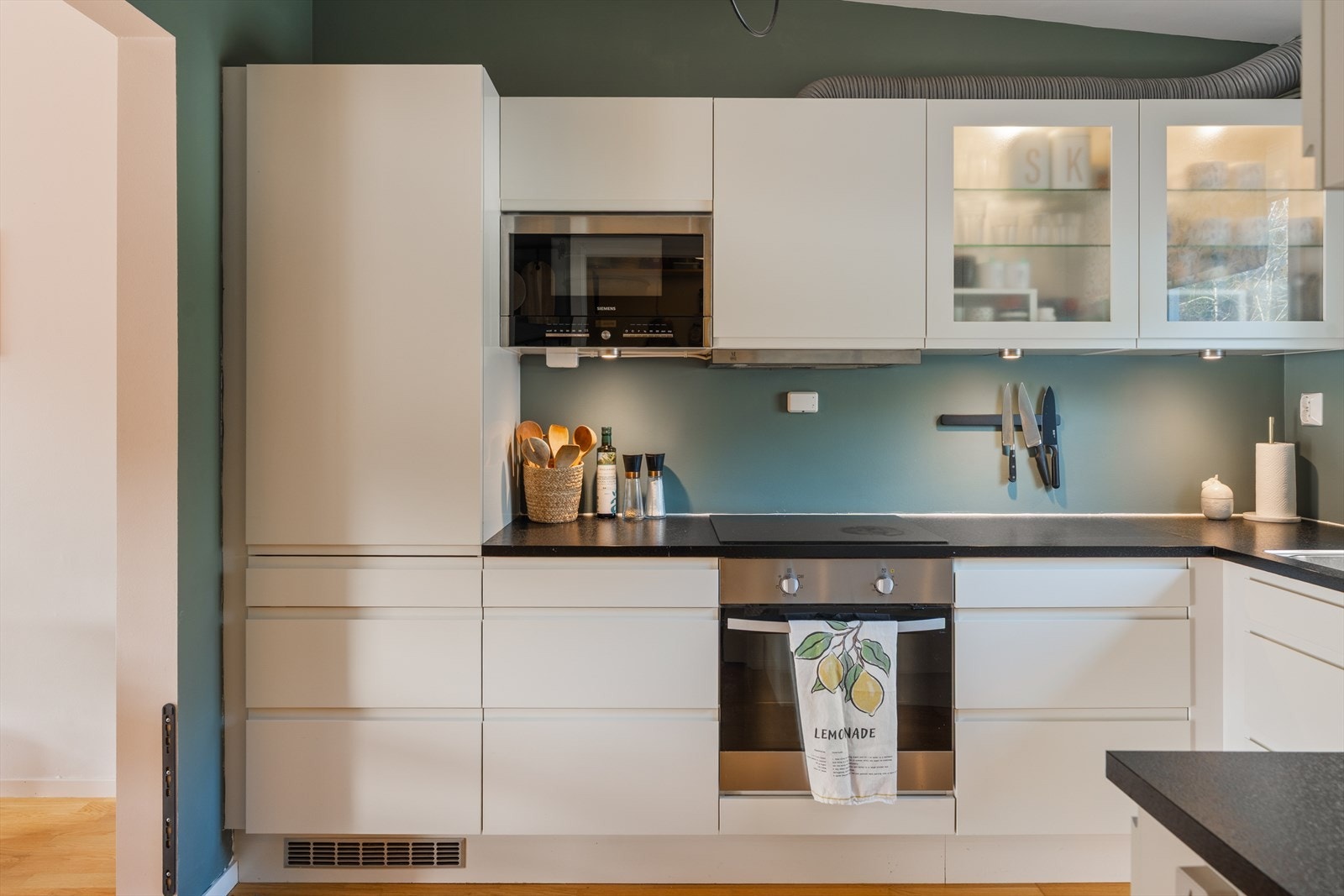 Kjøkkenet er romslig, tidløst og funksjonelt utformet med rikelig skap- og benkeplass. Levert av HTH. Galleribilde