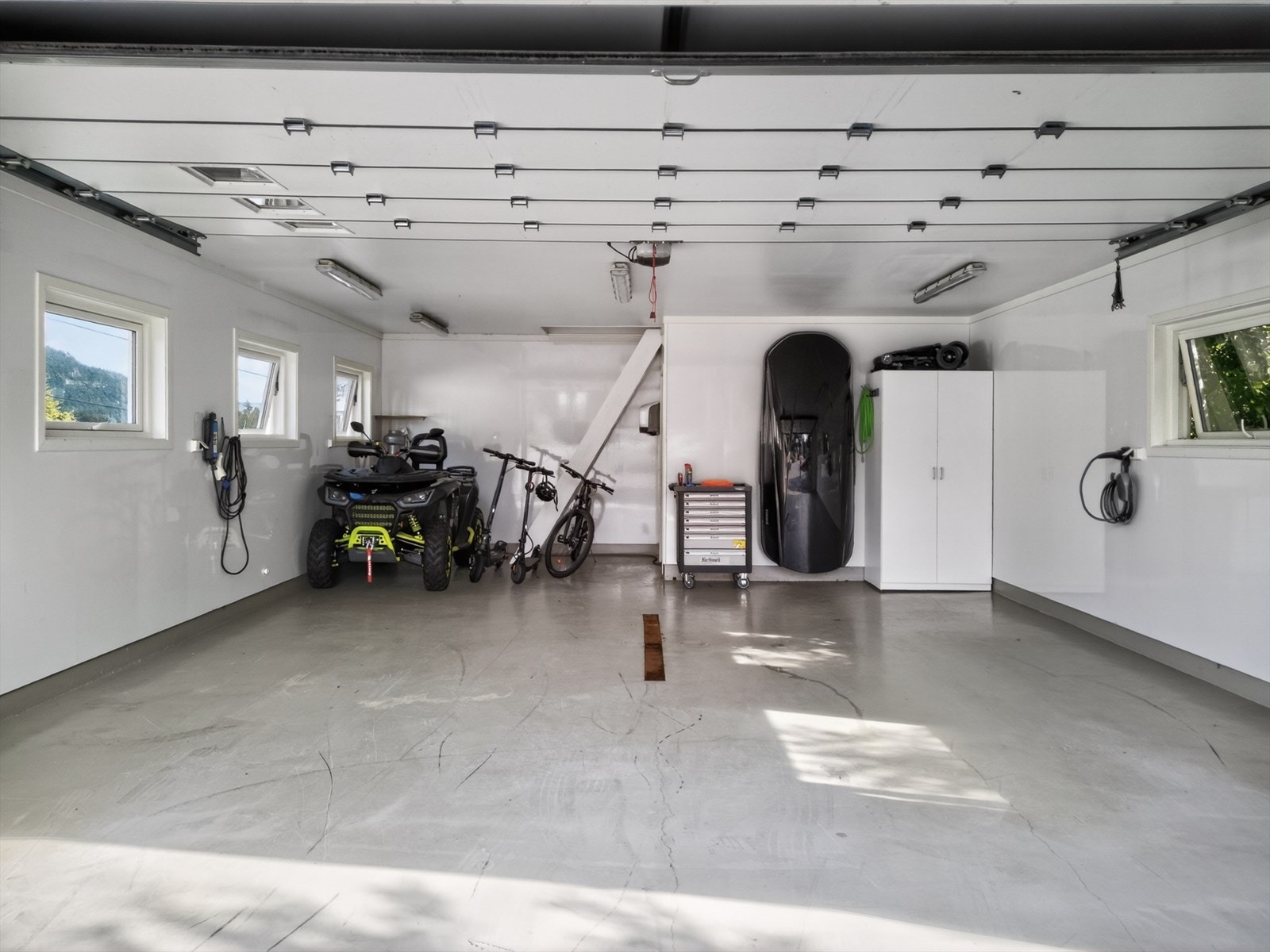 Ryddig garasje med epoxy gulv, baderomsplater og stor automatisk port Galleribilde