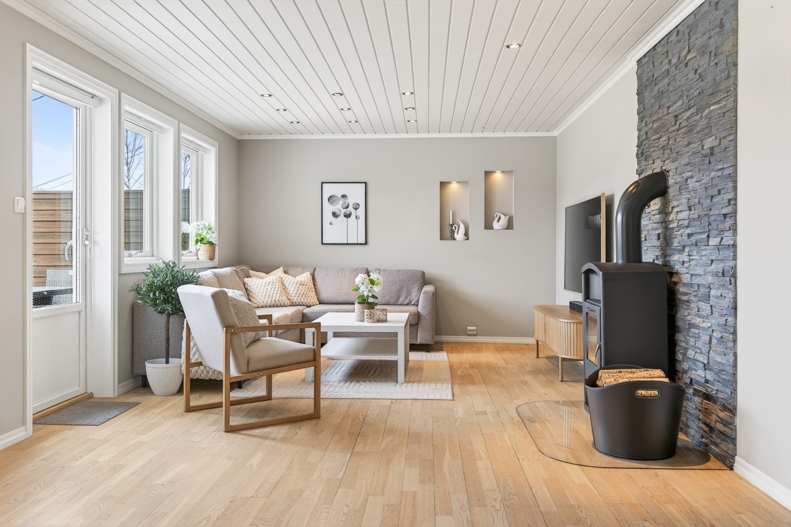 Lys og trivelig stue med peisovn og utgang til veranda Galleribilde