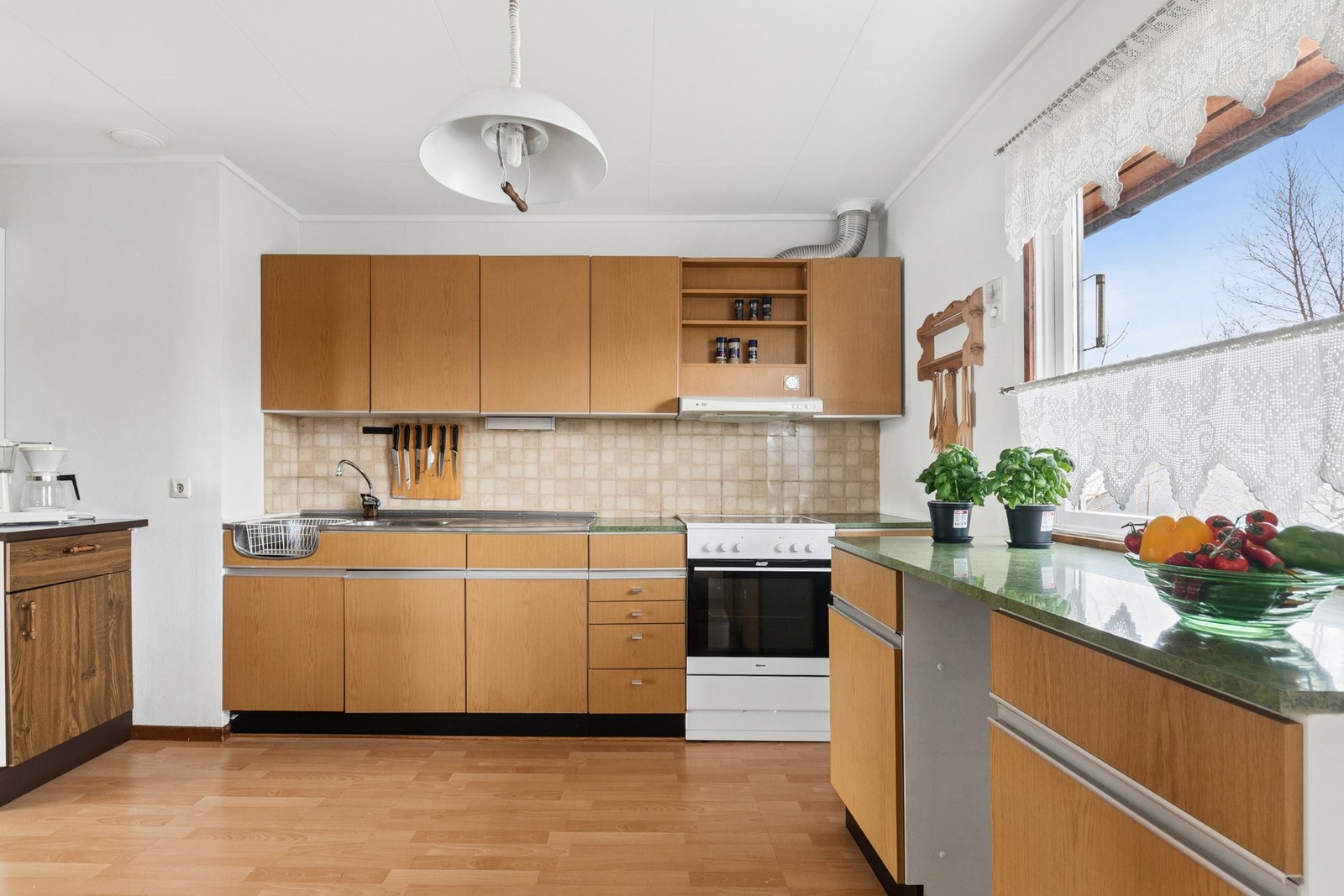 Kjøkkenet har innredning med glatte fronter, laminatbenkeplate og ventilator med avtrekk ut. Galleribilde