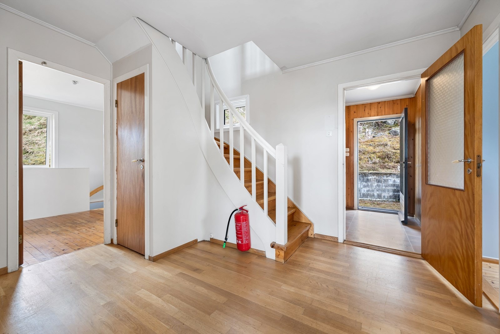 Romslig hall fra boligens entrè. Her er det også trapperom til kjeller. Galleribilde
