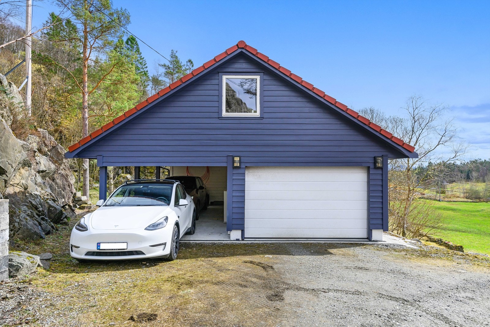 Garasjen ble bygget i 2013 i følge selger. Her er det god plass i både carport og lukket garasje. Det er innvendig trapp til loftet som selger har innredet i ettertid (ikke godkjent). Galleribilde