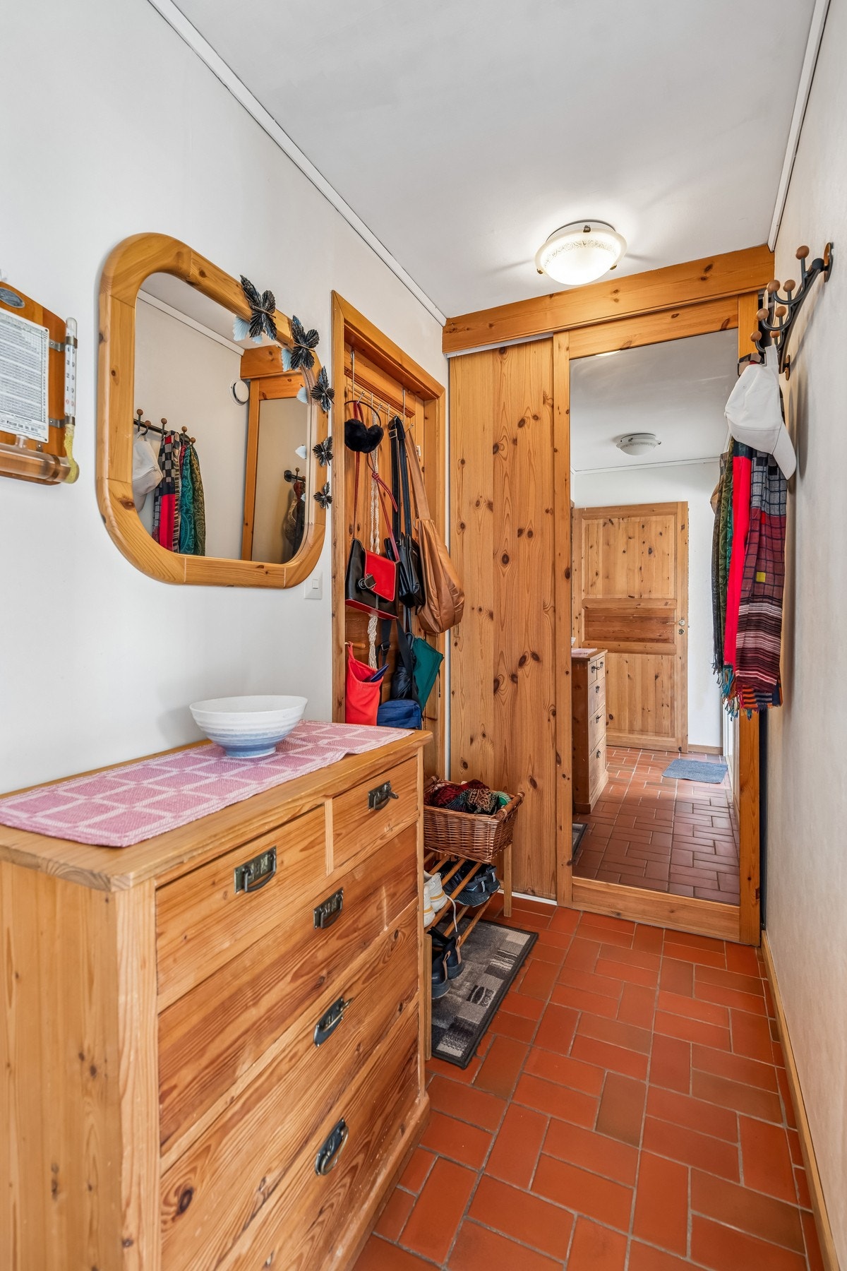 Entré med flislagt gulv og oppbevaringsplass i skyvedørsgarderobe. Galleribilde