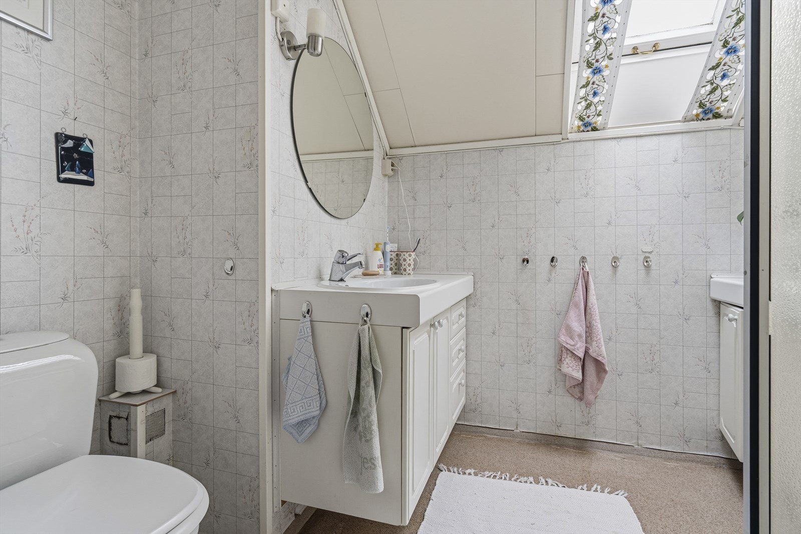 Badet i 2. etasje er innredet med nedfelt servant over skap, benk med skap, gulvstående toalett og dusjkabinett. Galleribilde