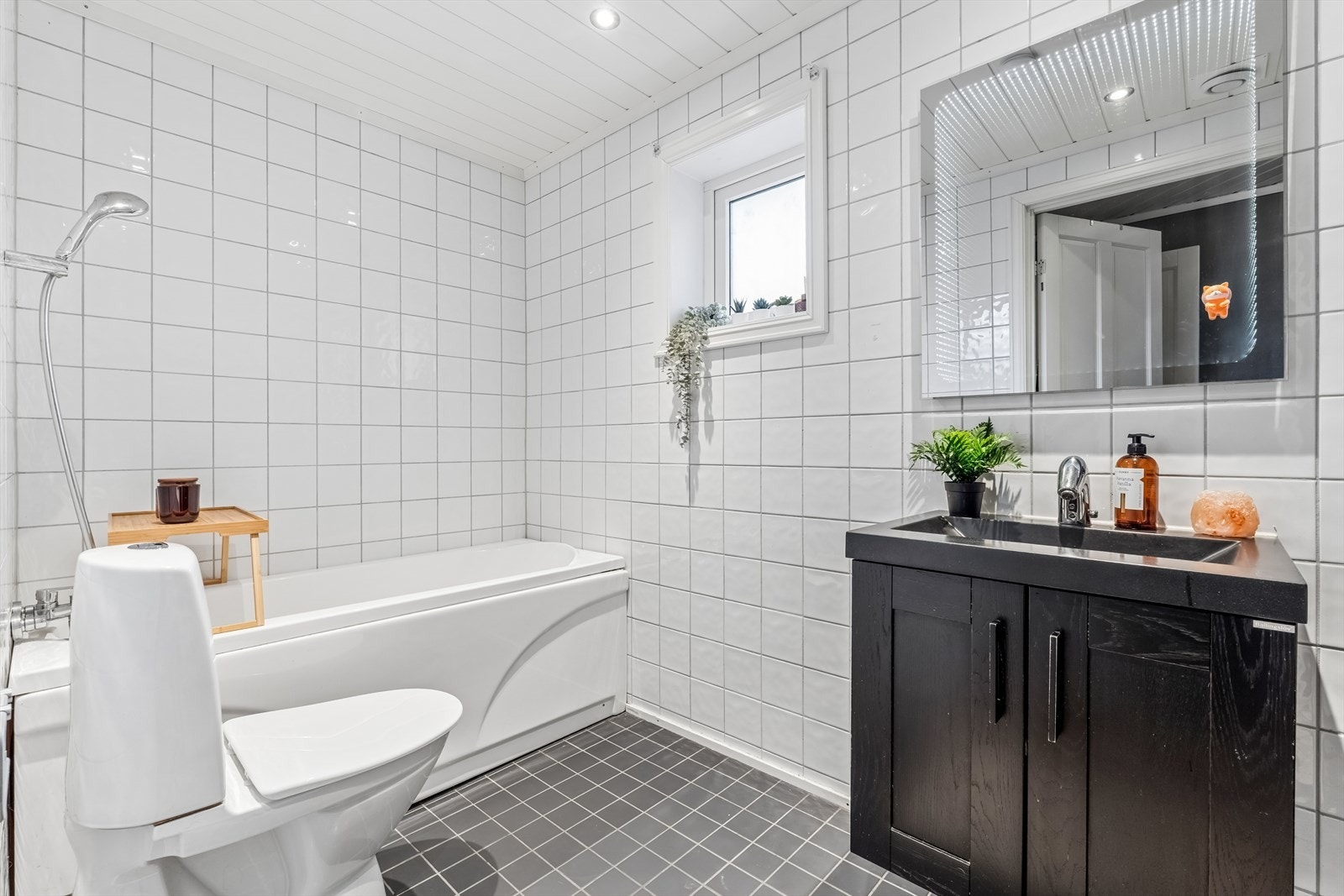Badet er innredet med badekar, toalett, servant med underskap og opplegg for vaskemaskin. Galleribilde