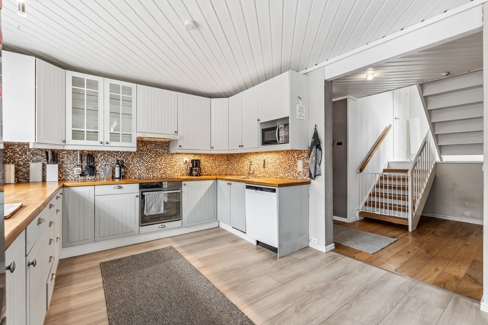 Lyst og pent kjøkken med profilerte fronter og benkeplate i heltre. Galleribilde