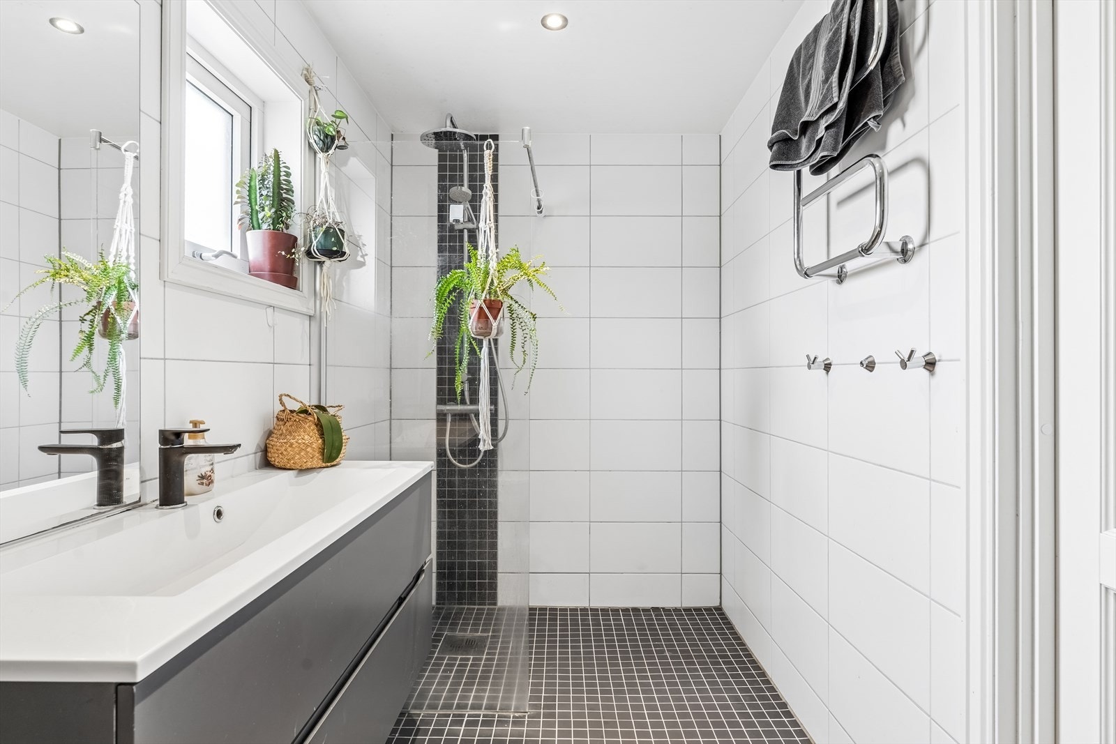 Badet er innredet med dusjhjørne, nedfelt servant med underskap, høyskap og toalett. Galleribilde
