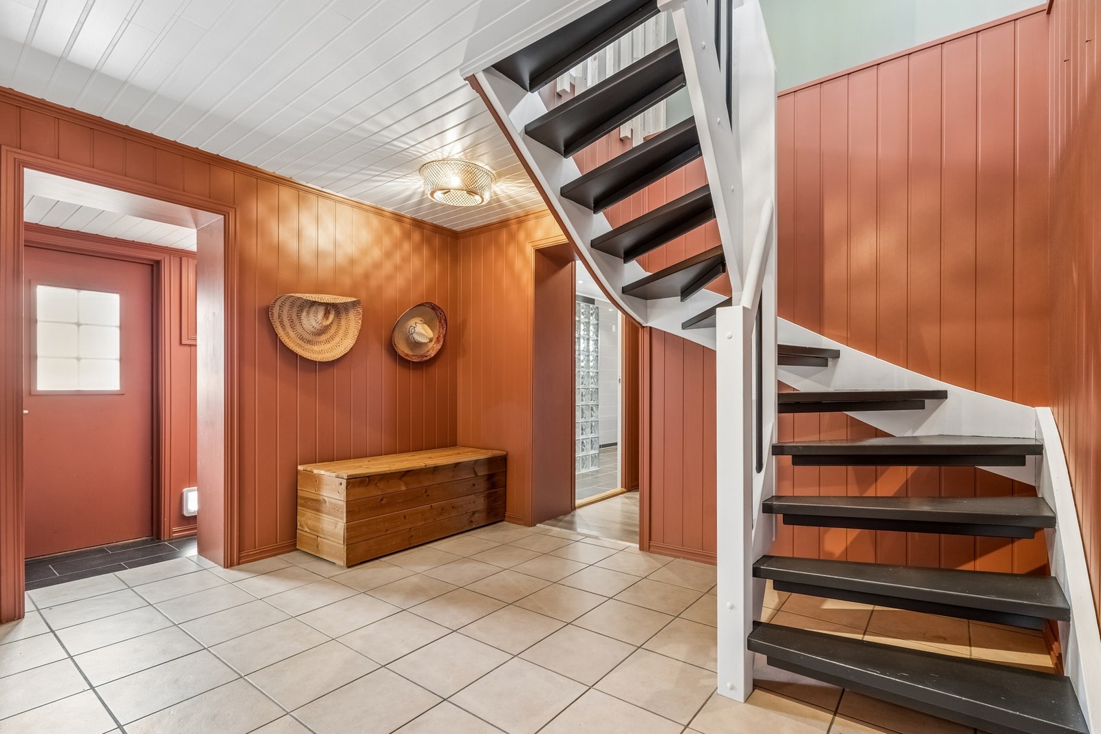 Flislagt hall med trapp opp til boligens 1.etasje. Galleribilde