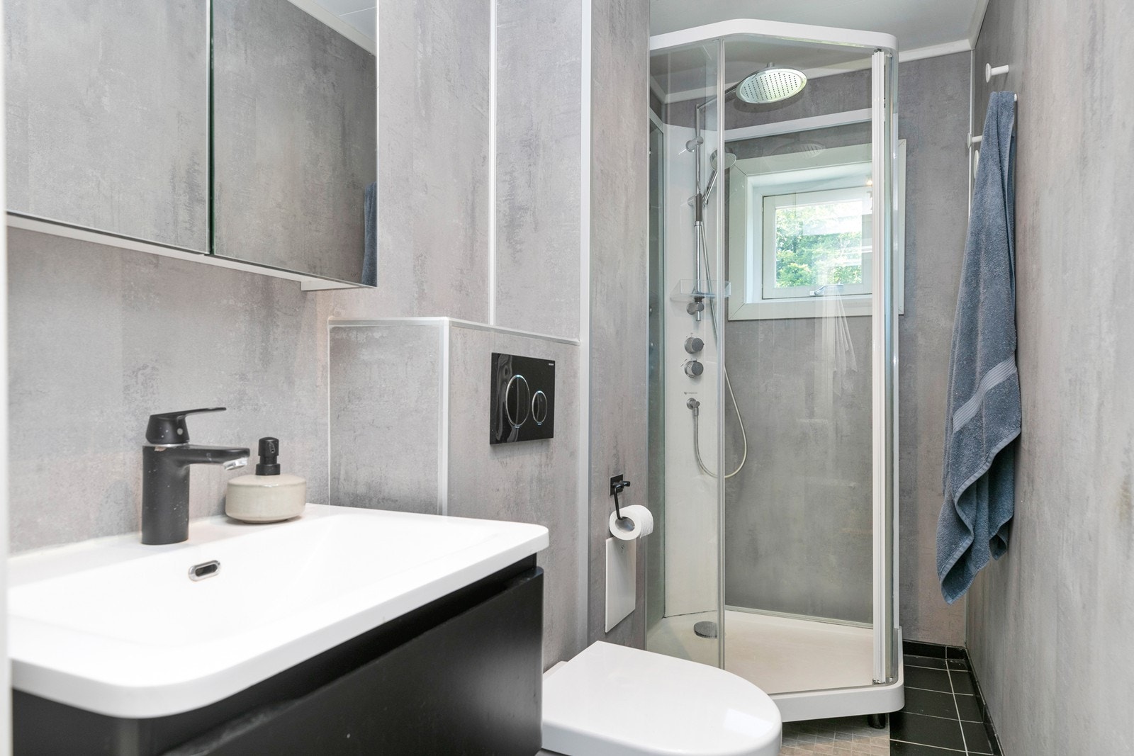 Badet ble renovert i 2020 og har flislagt gulv med gulvvarme, baderomsplater på veggene og et praktisk dusjkabinett. Galleribilde