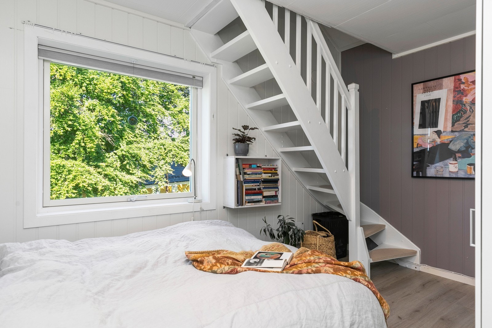 Fra soverommet fører en tretrapp med åpne opptrinn opp til leilighetens innredede loft. Galleribilde