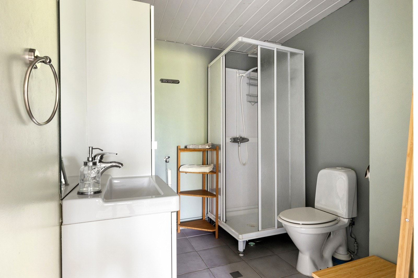 Badet i underetasjen er flislagt og oppført i 2006. Rommet er innredet med servantinnredning med speil, gulvmontert toalett og et praktisk dusjkabinett. Galleribilde