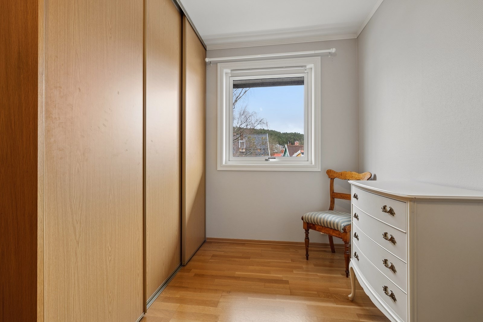 En hel vegg med skyvedørsgarderobe med innredning gir utmerket lagringsplass på hovedsoverommet. Galleribilde