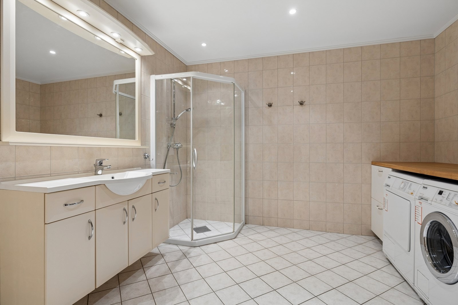 Badet er utstyrt med klassisk innredning, dusjhjørne og veggmontert toalett. Galleribilde