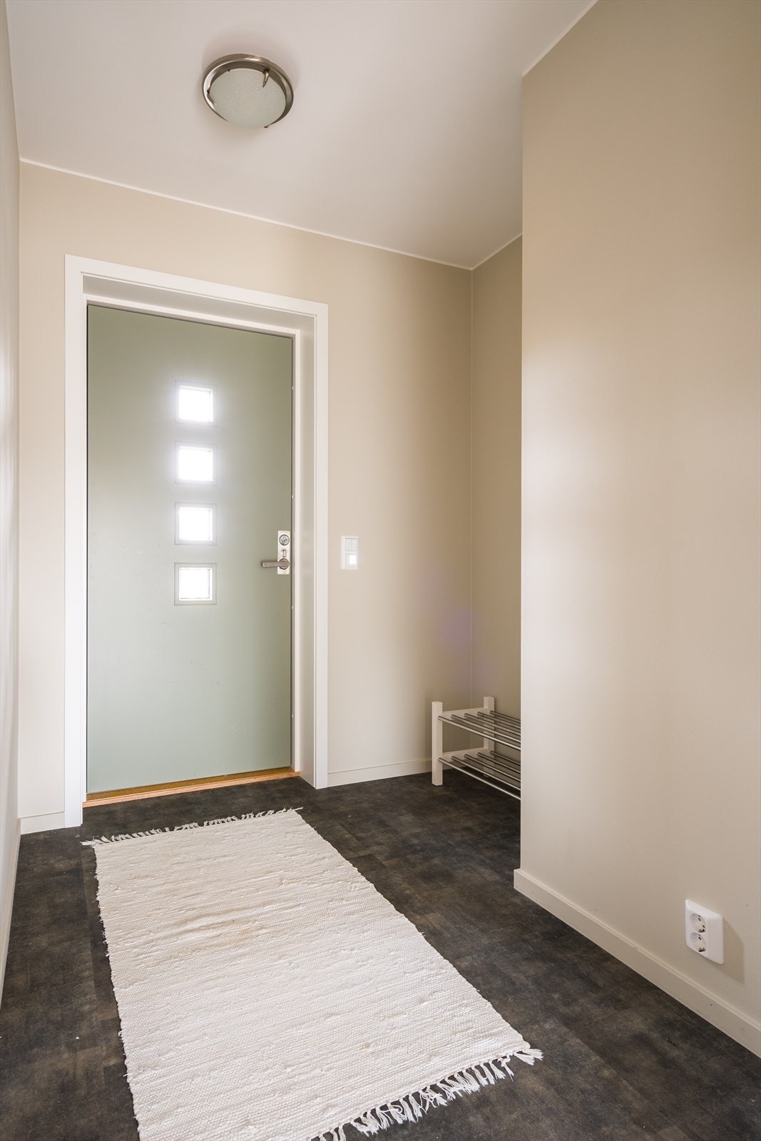 Laminatgulvet i entréen gir en slitesterk overflate i inngangspartiet. Fabrikkmalt ytterdør med glassfelt gir naturlig lysinnslipp. Galleribilde