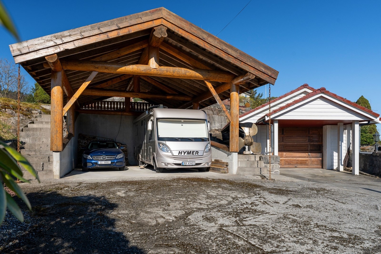 Det er oppført både garasje og carport i front. Det er innlagt strøm i garasjen. Galleribilde