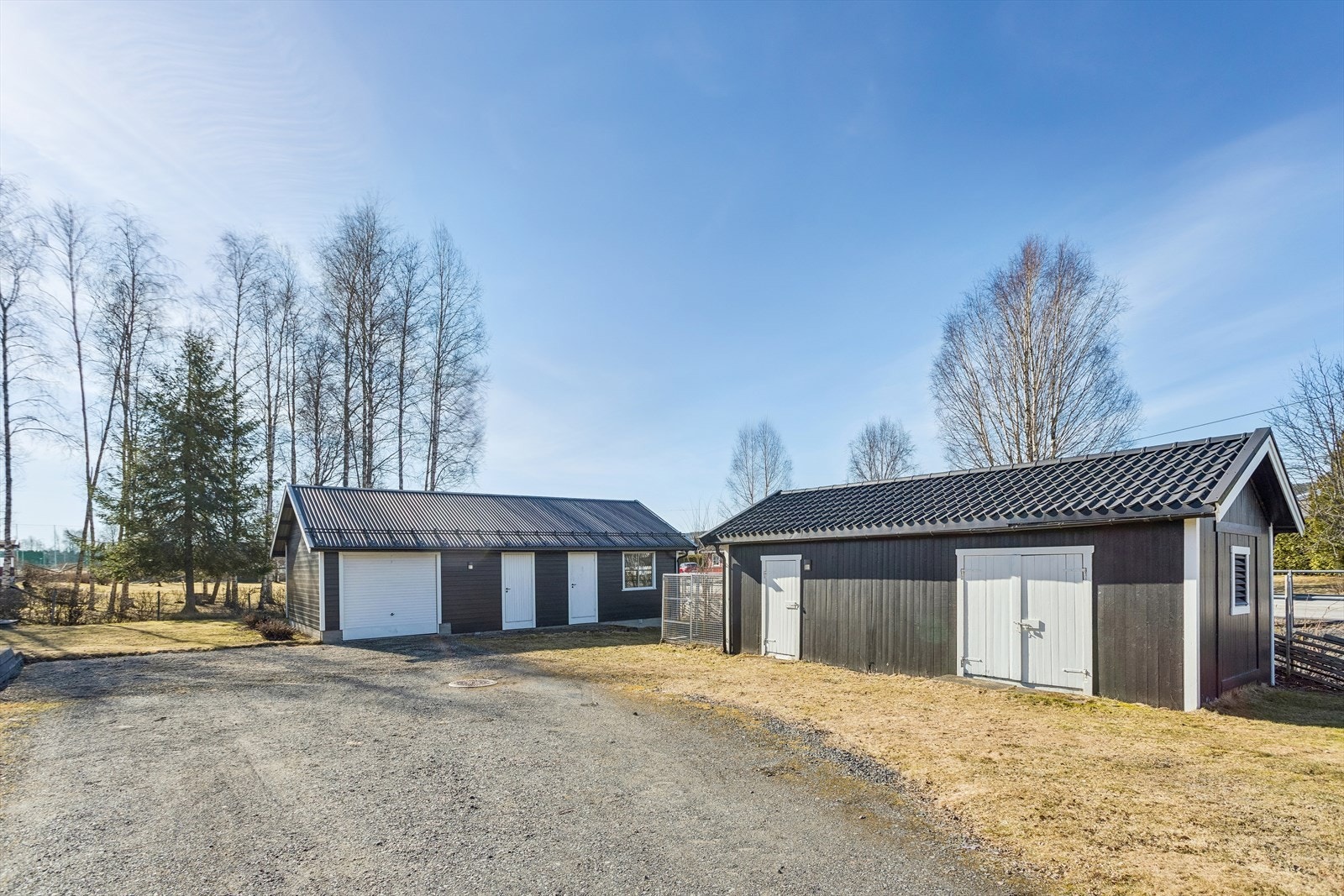 Eiendommen inkluderer en stor gårdsplass med biloppstillingsplasser foran garasje på 62 m² med hobbyrom og boder. Separat uthus på 33 m² med boder. Galleribilde