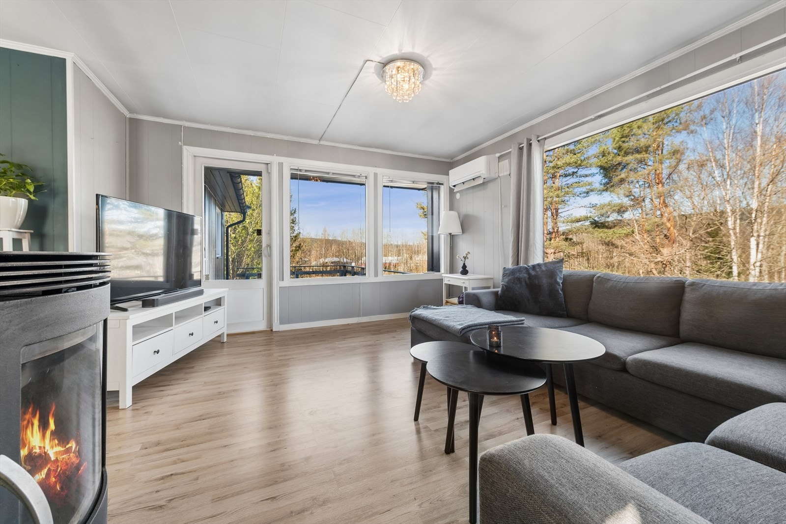 Det er store vindusflater i stuen som slipper lyset og naturen inn. Galleribilde