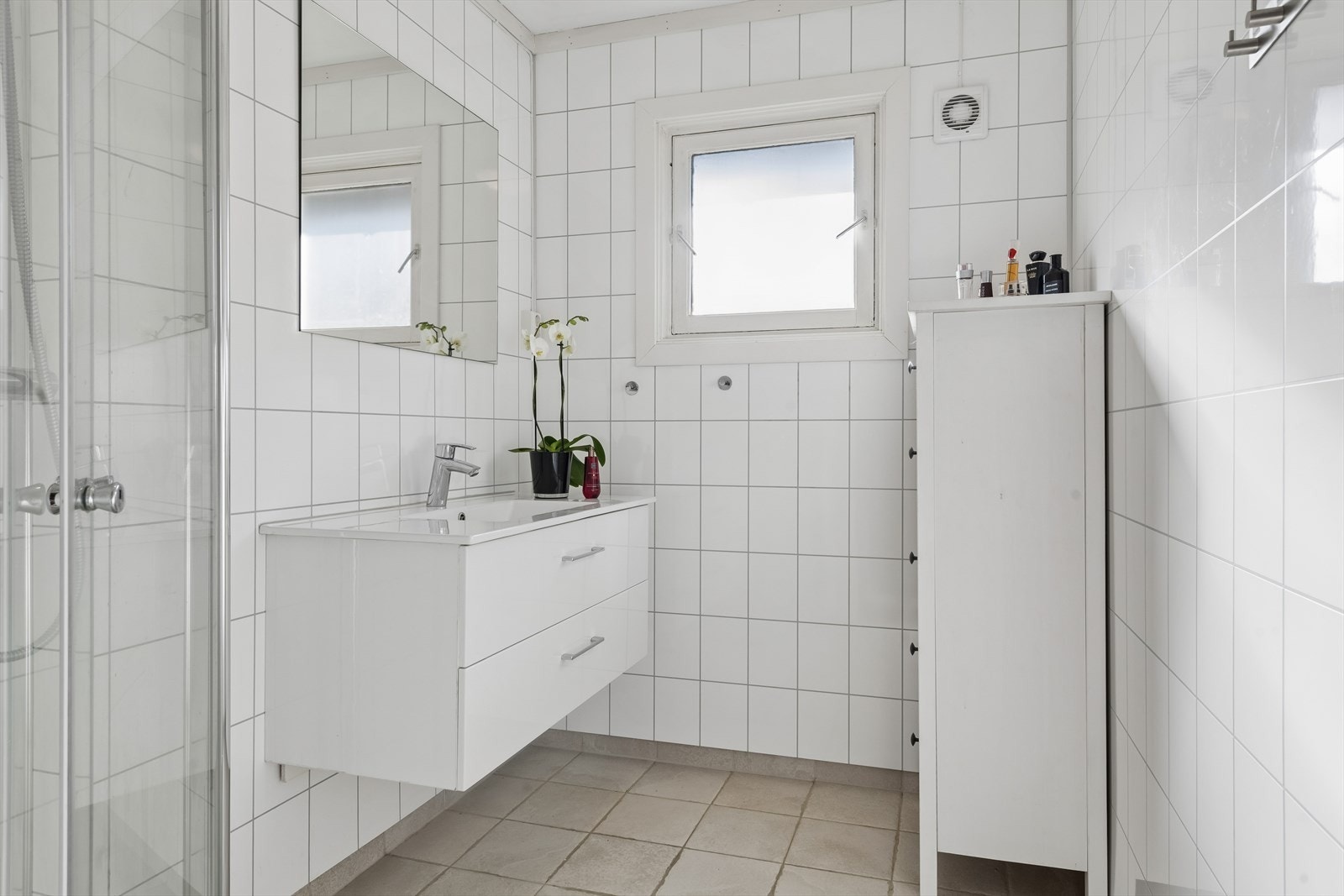 Lyst og pent bad fra 2018 som inneholder badeomsinnredning og dusjhjørne. Galleribilde