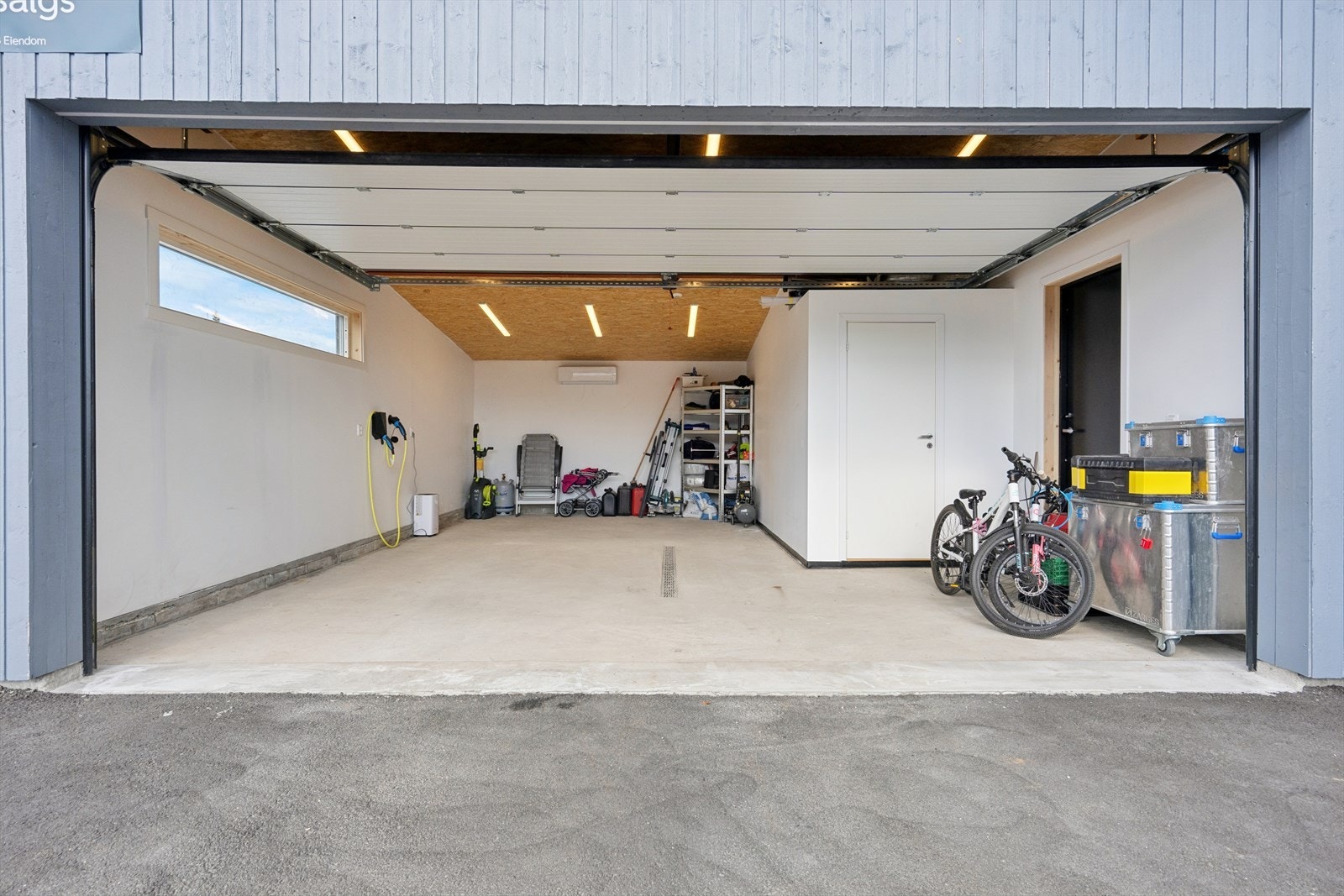 Stor garasje med elbillader, varmepumpe og bod. Galleribilde