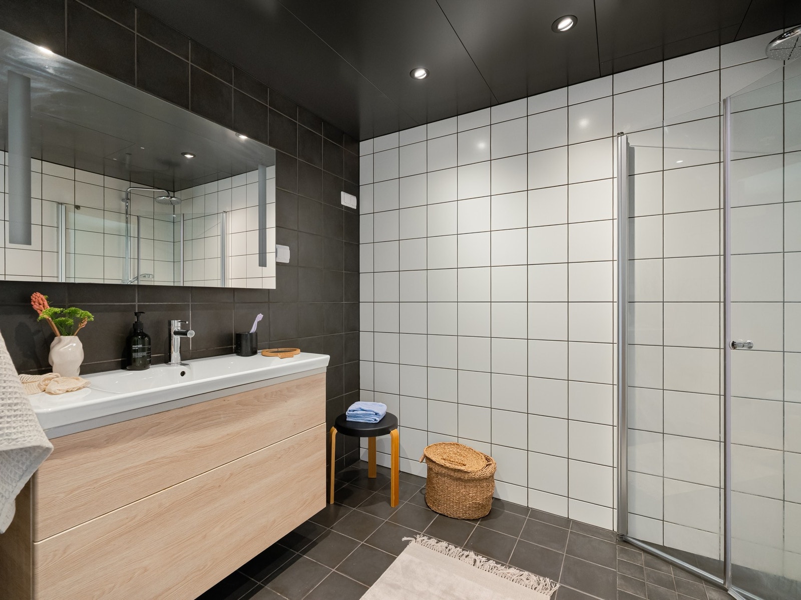 Badet er pent flislagt og fra byggeår 2022. Det er innredet med dusjsone med innfellbare glassdører, vegghengt toalett, servantskap med oppbevaring og speilskap på vegg. Galleribilde
