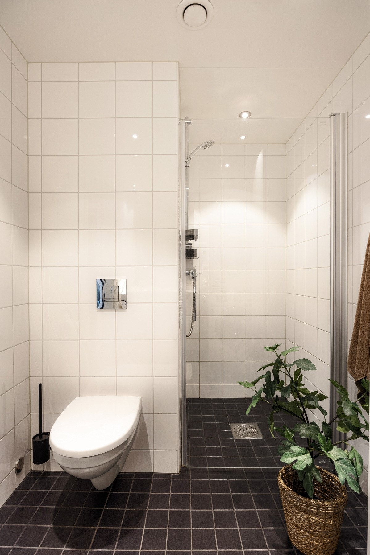 Badet i hovedetasjen er flislagt og her finner du vegghengt WC, dusj i nisje og servant med ettgreps blandebatteri i innredning. Galleribilde