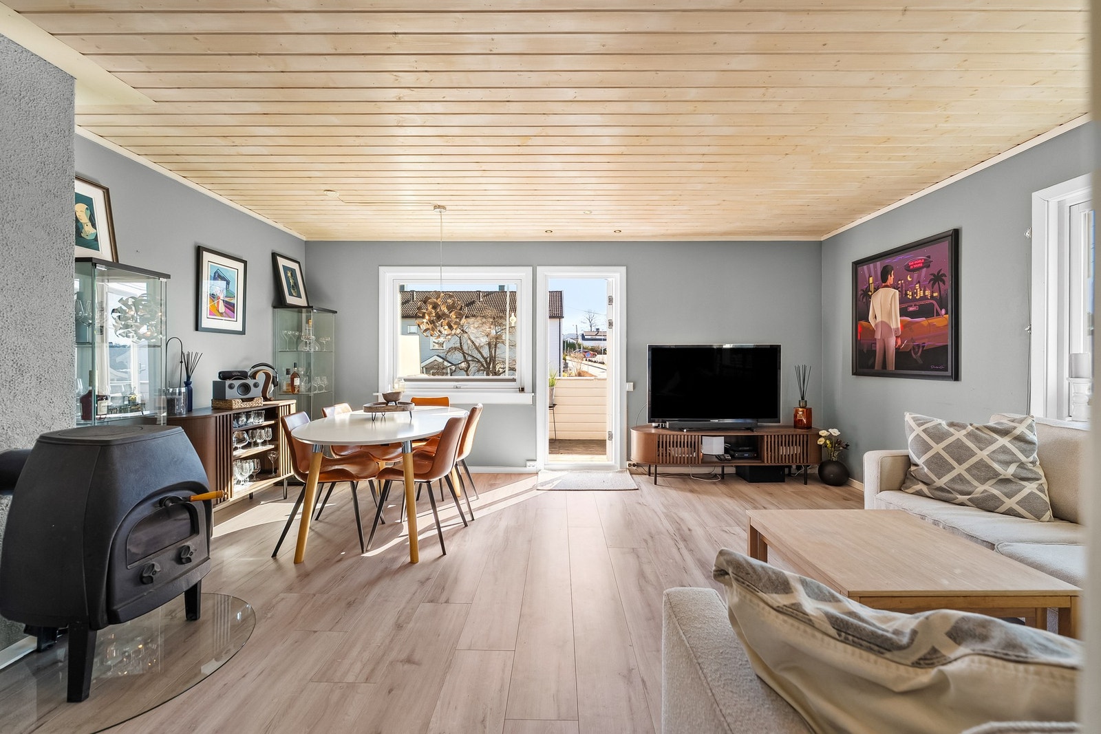 Lys og åpen stue med laminat på gulv og malte veggflater. Galleribilde