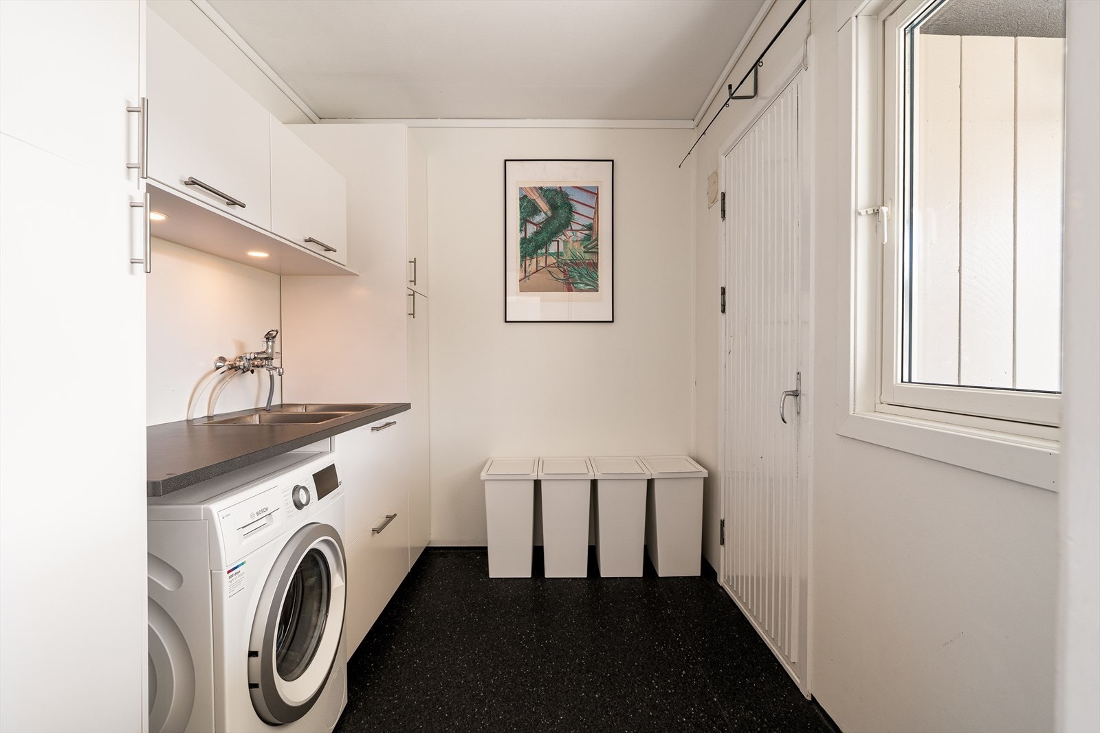 Rommet har slitesterkt vinylbelegg på gulv og malte flater på vegger og himling. Innredningen består av skap og skuffer med laminert benkeplate og utslagsvask i stål. Galleribilde