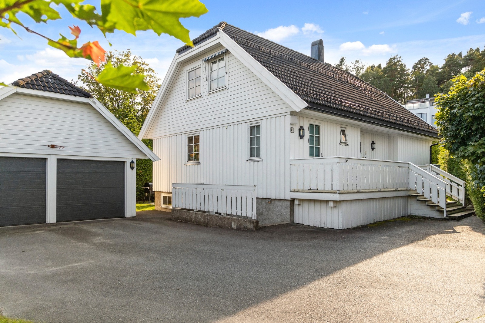 Asfaltert gårdsplass med dobbel garasje. Galleribilde