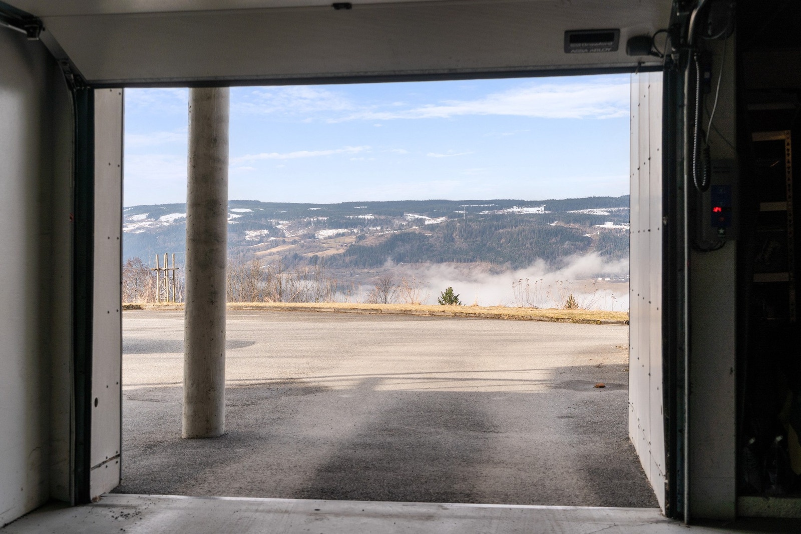 Innkjøring til parkeringskjelleren under blokka, med fjernstyrt garasjeportåpner. Galleribilde