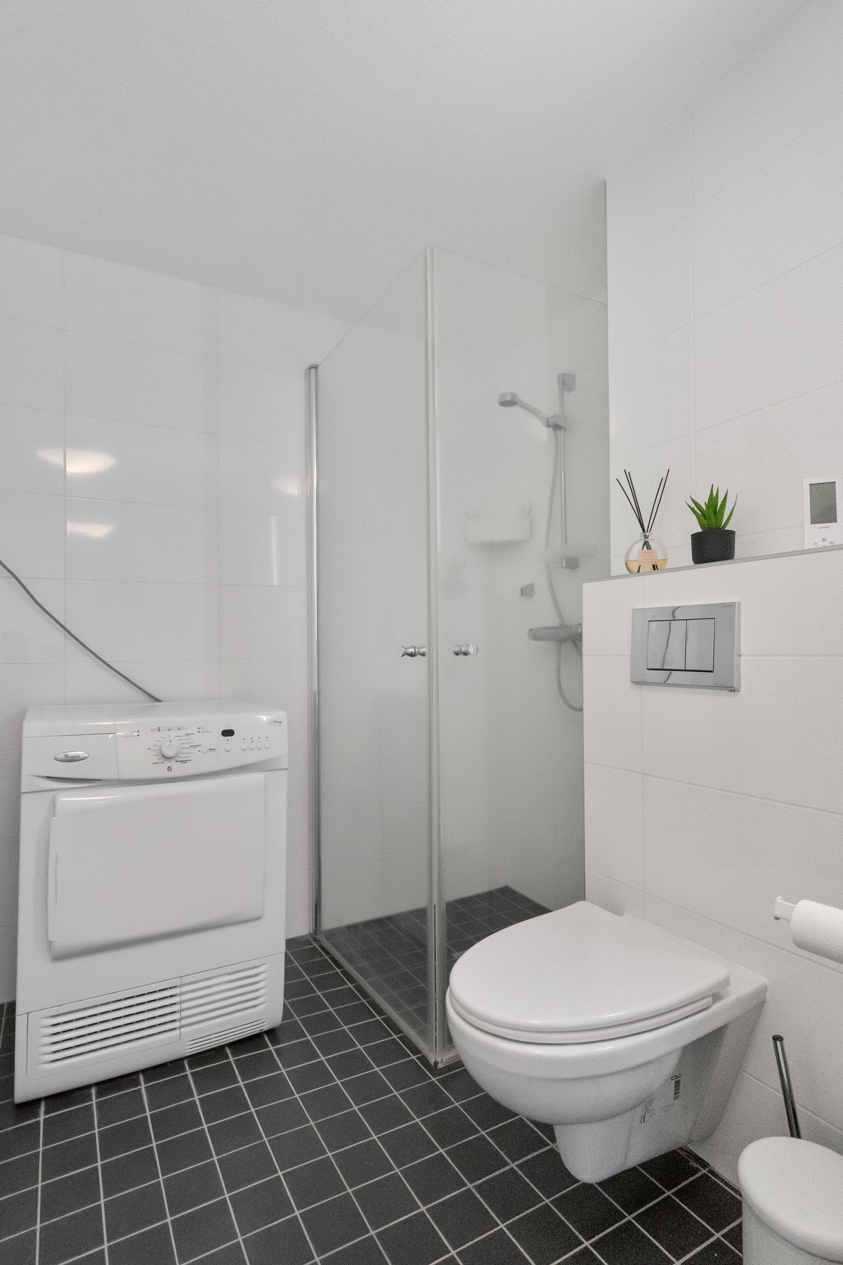 Badet er utstyrt med dusj og vegghengt toalett. Galleribilde