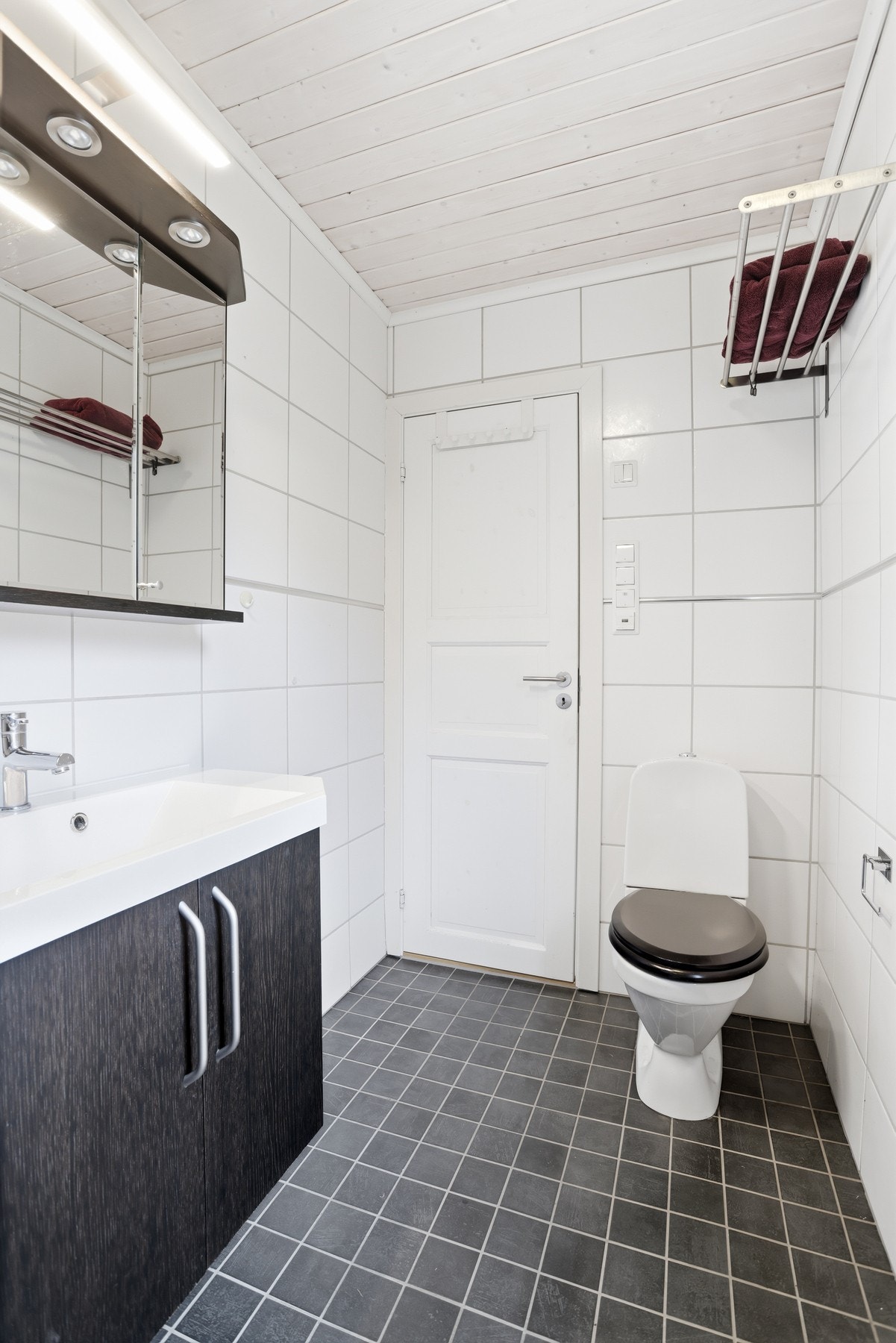 Badet inneholder innredning med servant, speilskap, toalett, og dusjhjørne med glassdører Galleribilde