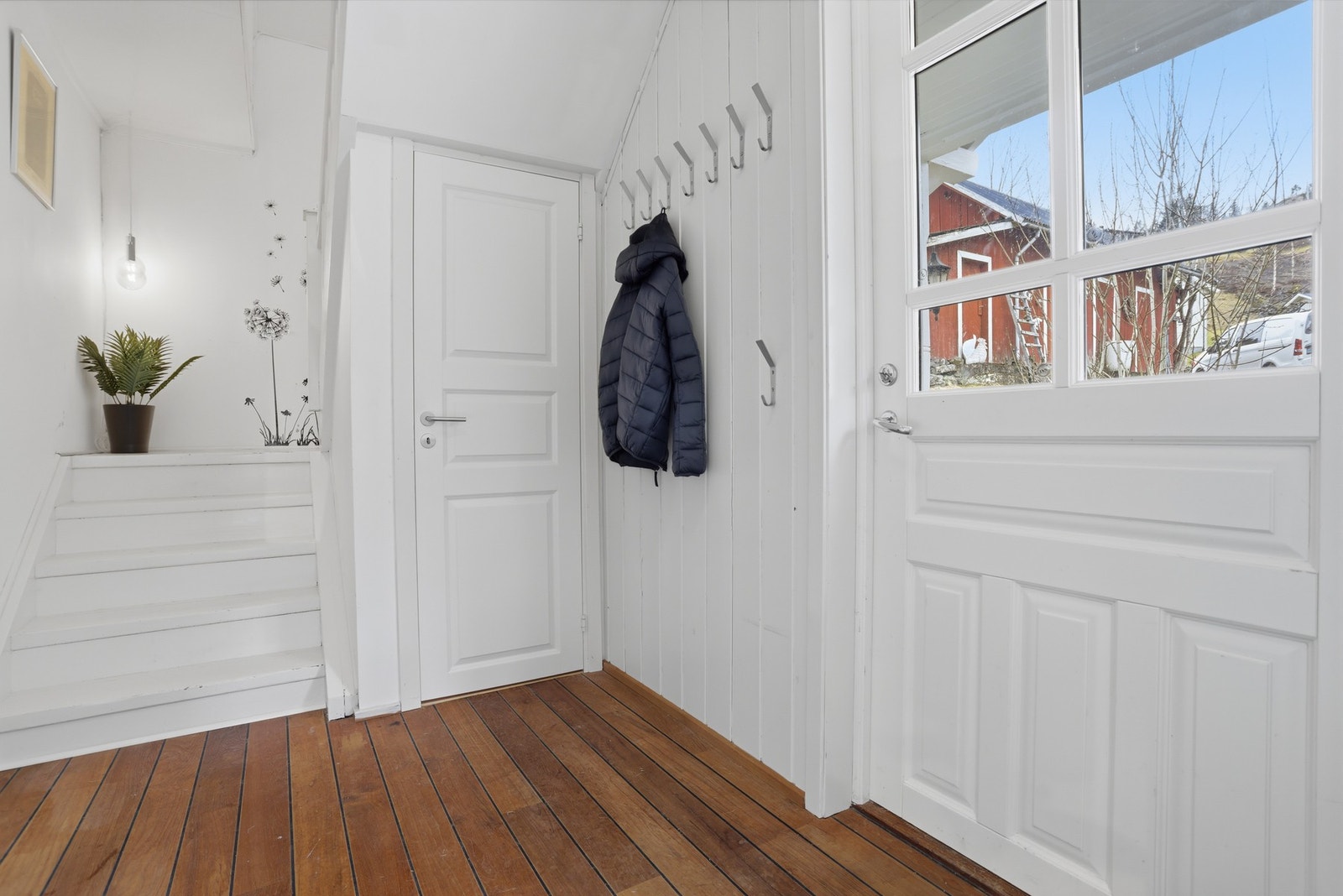 Lys og innbydende entré med plass til oppbevaring av yttertøy og sko Galleribilde