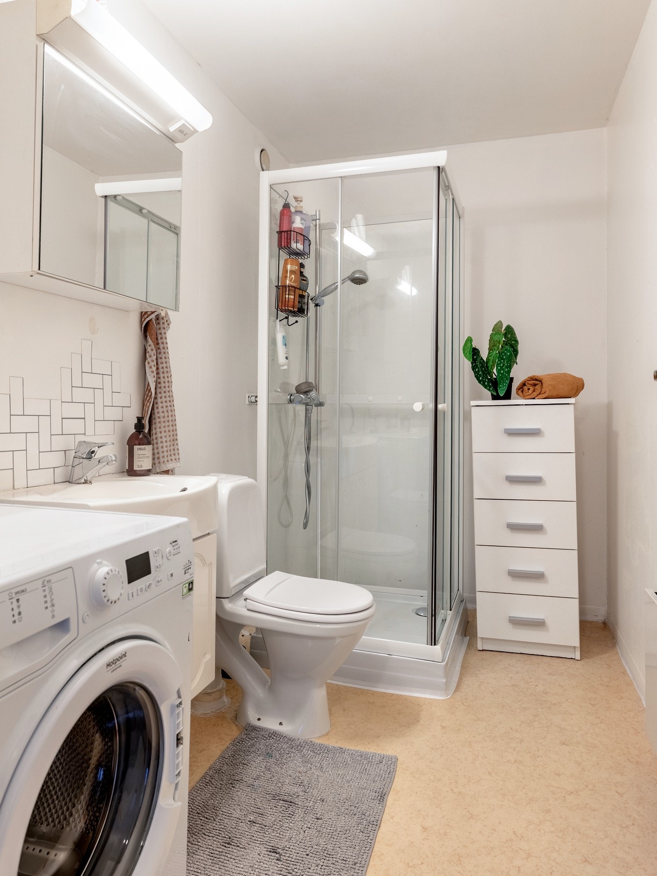 Badet har malt tapet på veggene og banebelegg på gulvet. Galleribilde