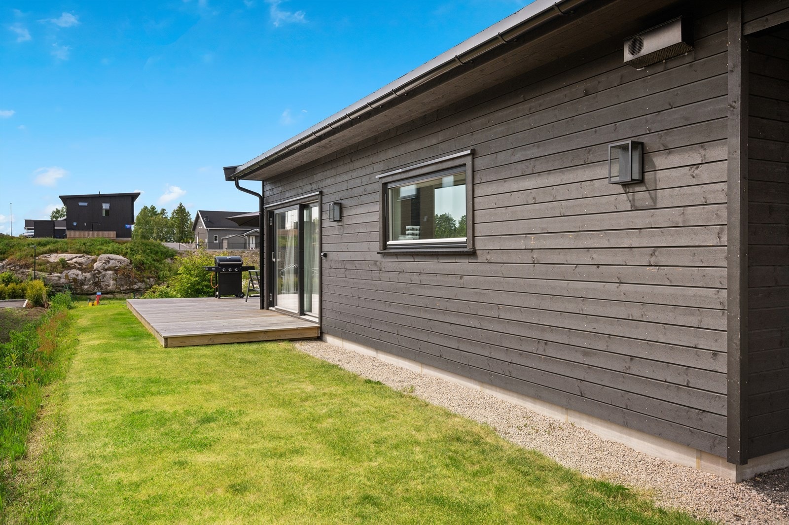 Det er direkte utgang fra spisestueområdet til en innbydende uteplass. Galleribilde