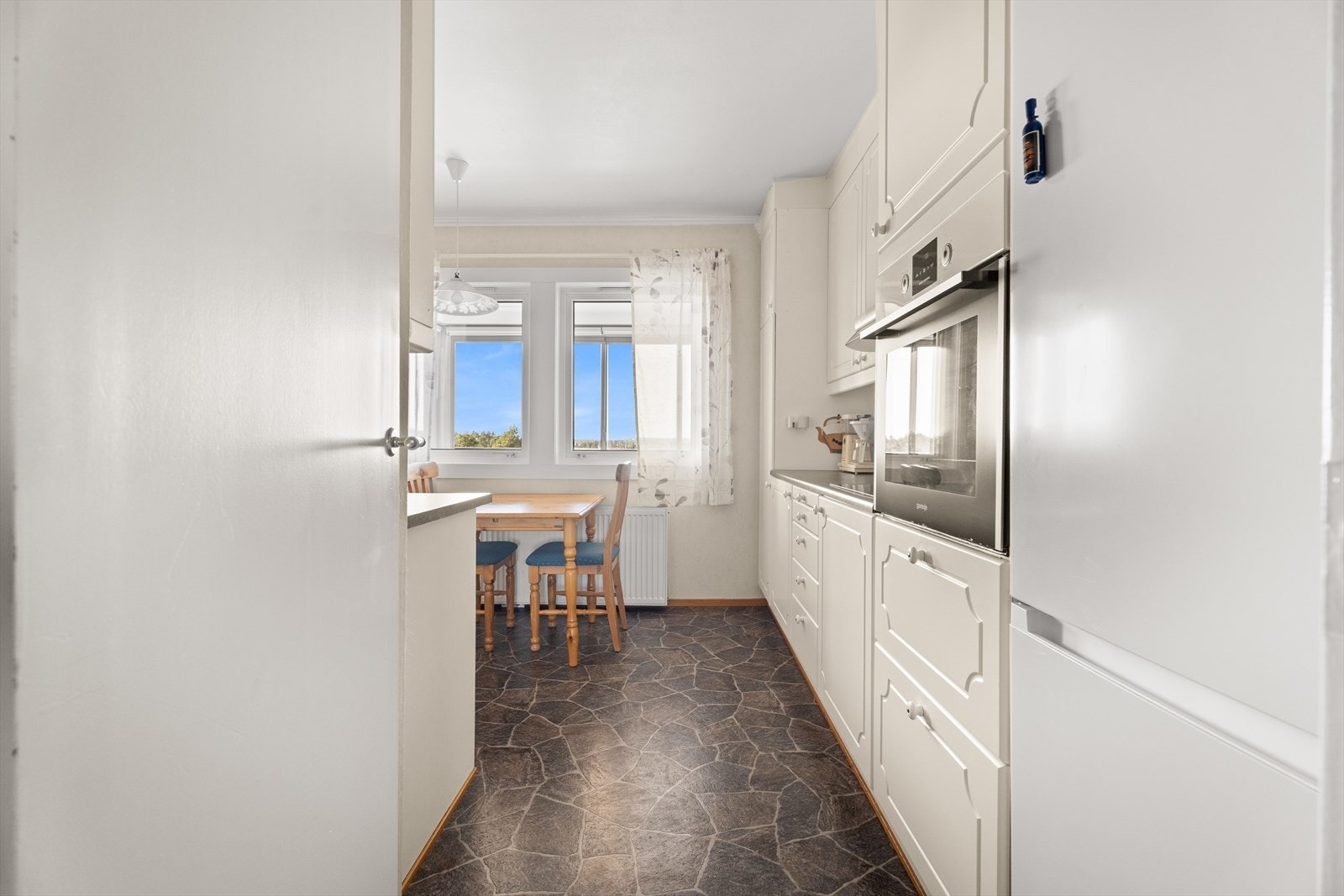 Kjøkkeninnredningen har lyse, profilerte fronter og en slitesterk, laminert benkeplate. Galleribilde