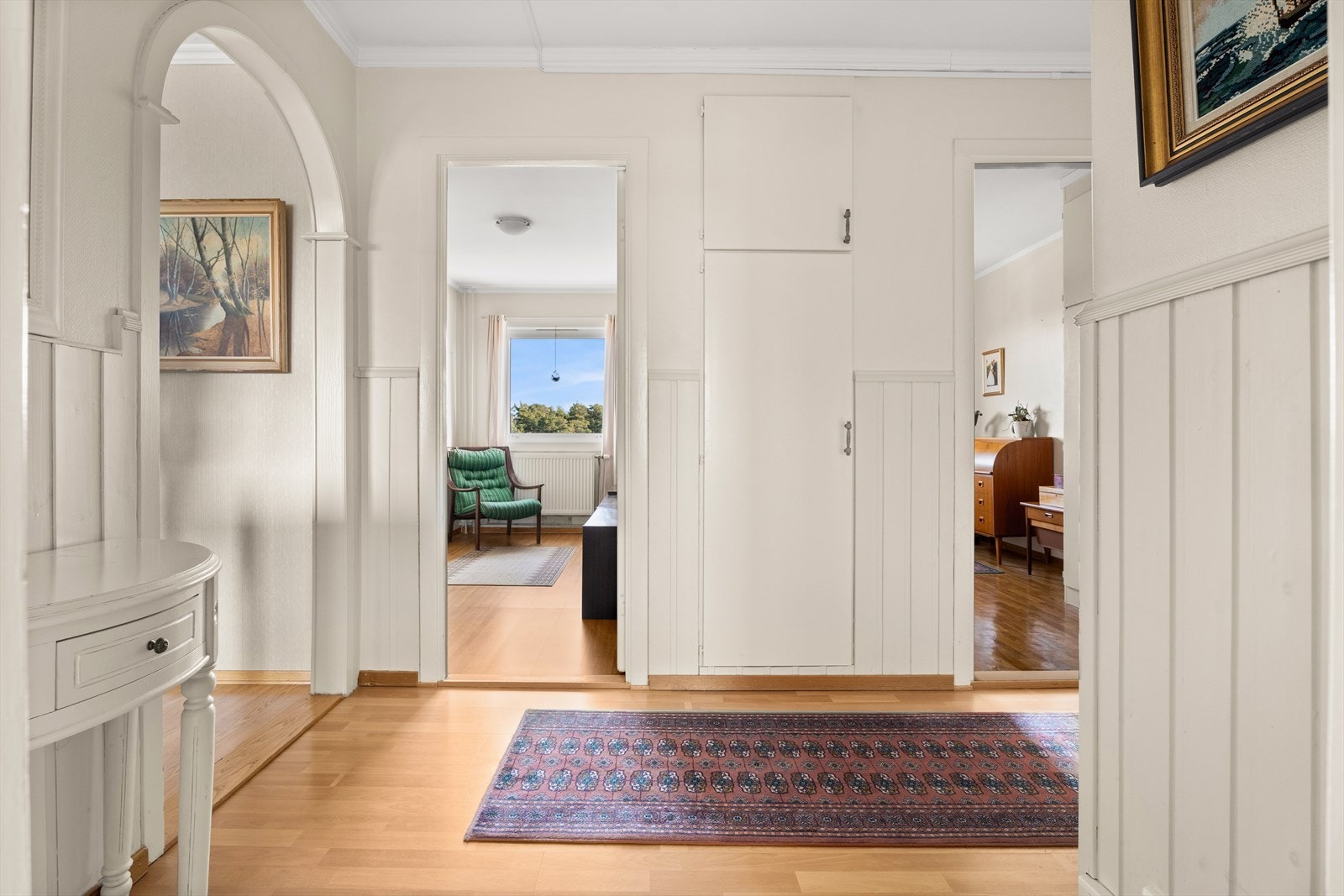En elegant bueåpning leder fra gangen og inn mot stuen og spisestuen. Galleribilde