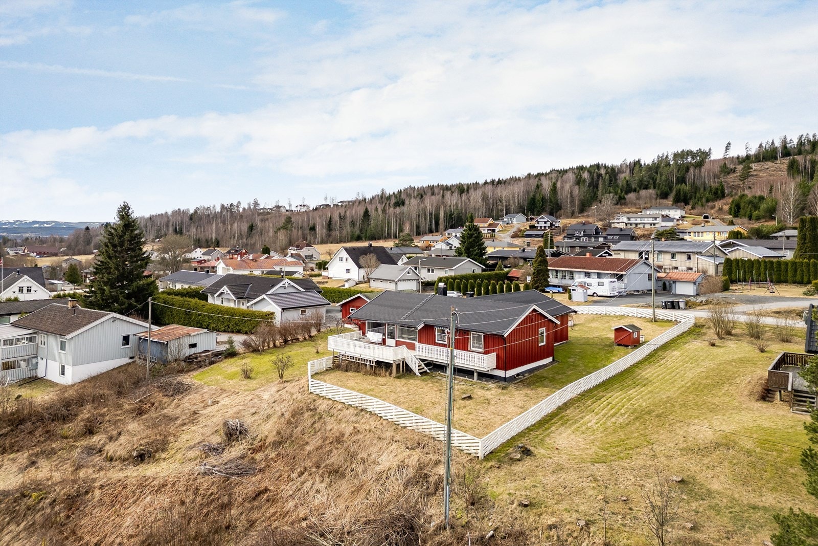 Tomten er på ca. 1 561,7 m² og opparbeidet med plen og beplantning, og deler er inngjerdet med hvitt stakittgjerde. Galleribilde