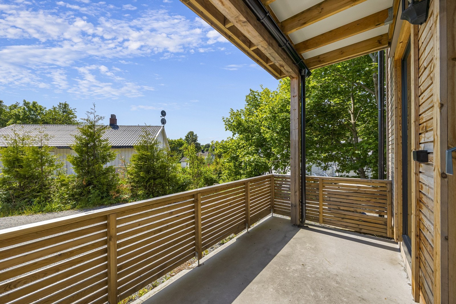 Terrassen på 11 m² er utført i betong og behandlet tre, og gir en fin, privat uteplass. Galleribilde