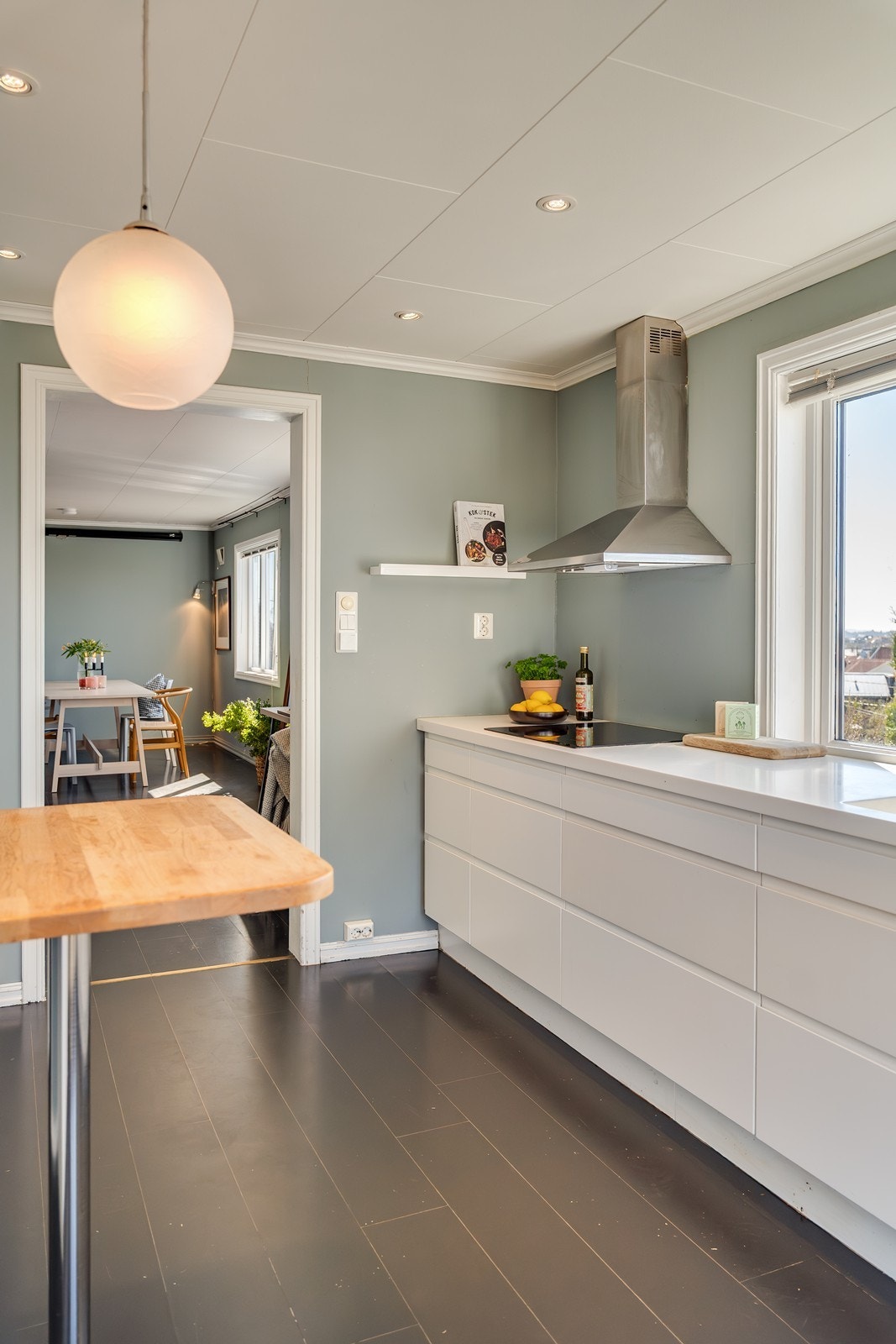 Lekkert og moderne kjøkken utført med slette fronter og benkeplate av laminat og heltre med nedfelt vask. Galleribilde