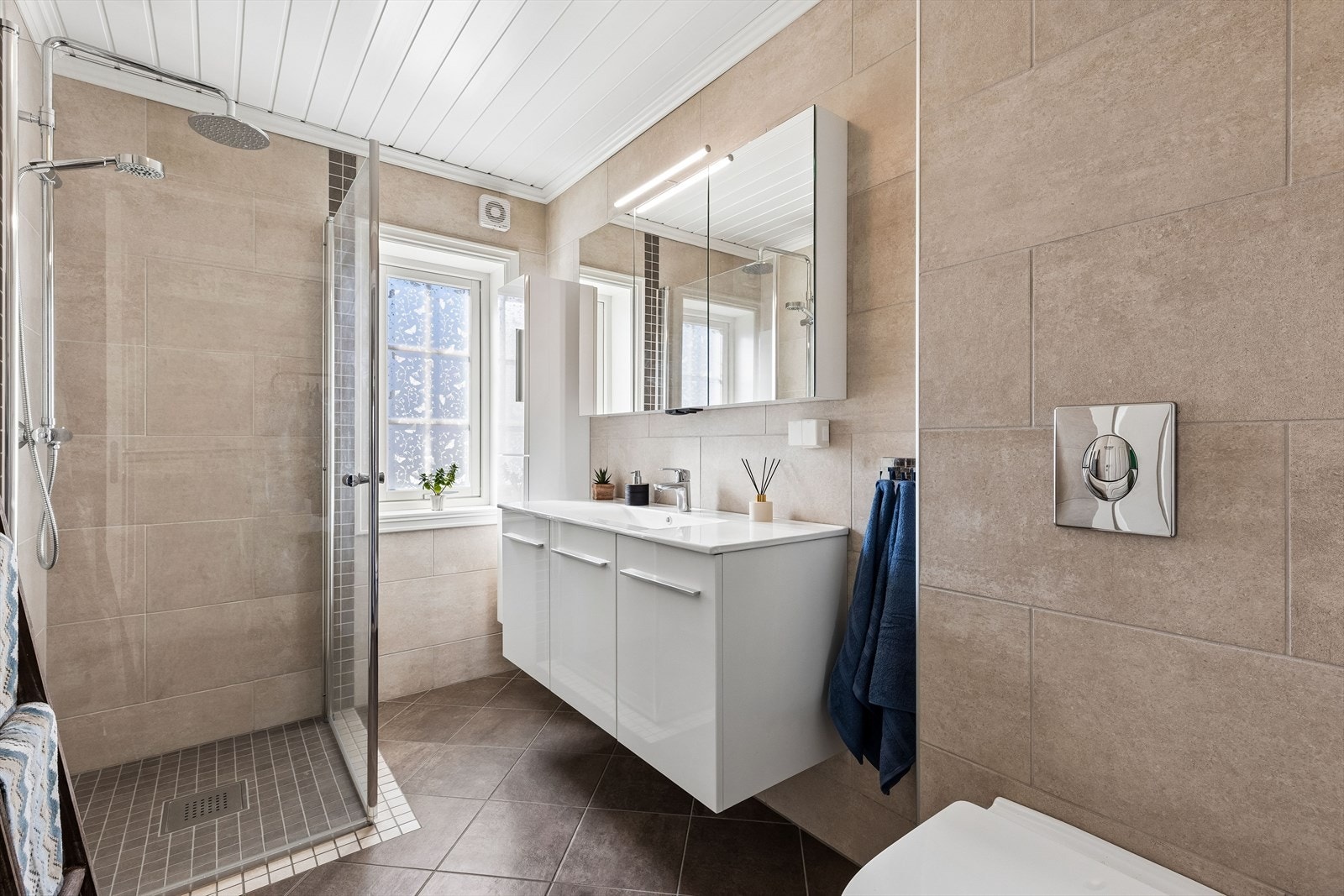 Badet er utstyrt med vegghengt toalett og dusjhjørne med regnfallsdusj. Galleribilde