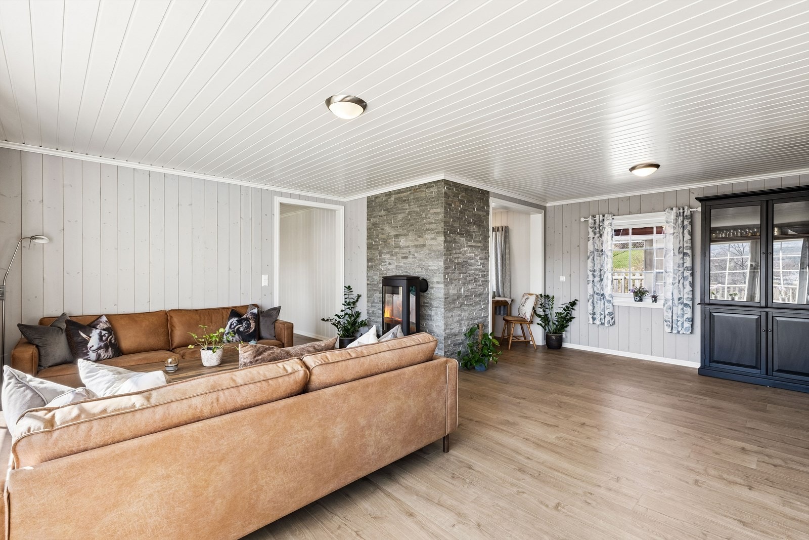 Gjennomgående laminatgulv og lyse panelvegger gir et helhetlig og moderne uttrykk. Galleribilde