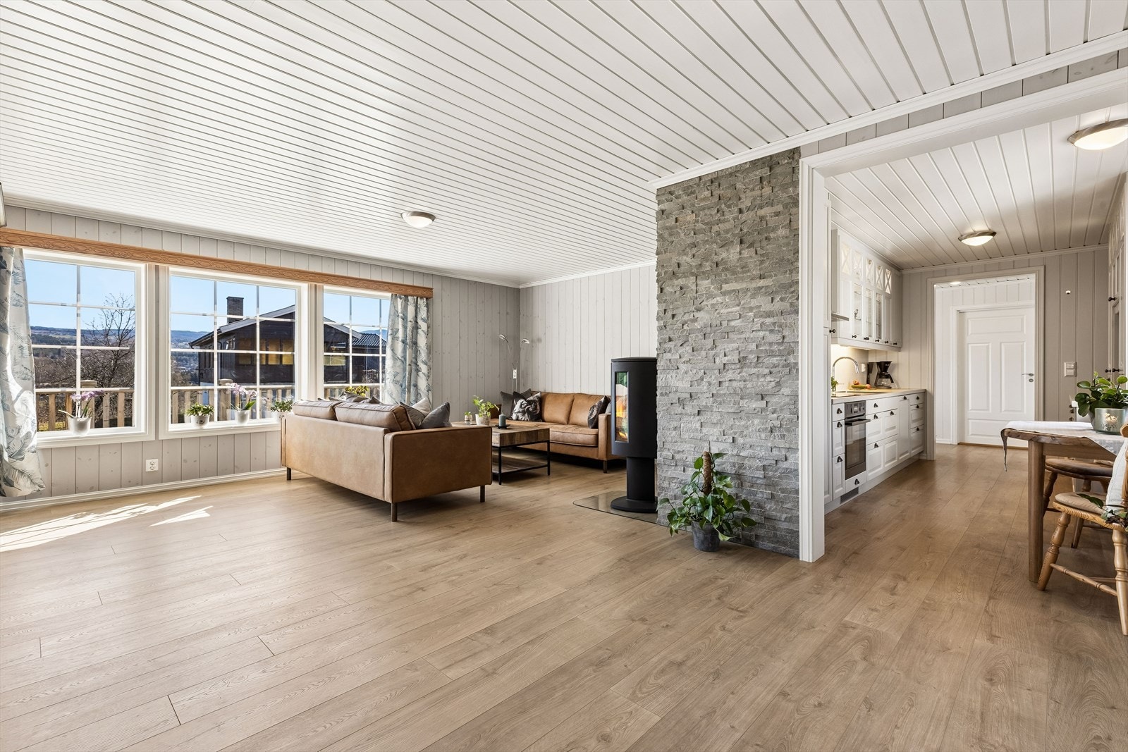 Stuen er romslig og har en delvis åpen løsning mot kjøkkenet, noe som skaper en sosial og luftig atmosfære. Galleribilde