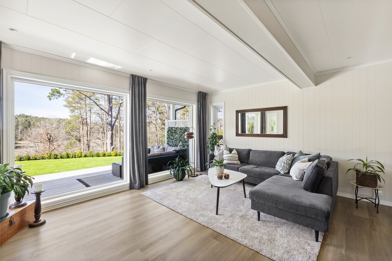 Store vindusflater som gir rikelig med naturlig lys inn i stuen. Galleribilde