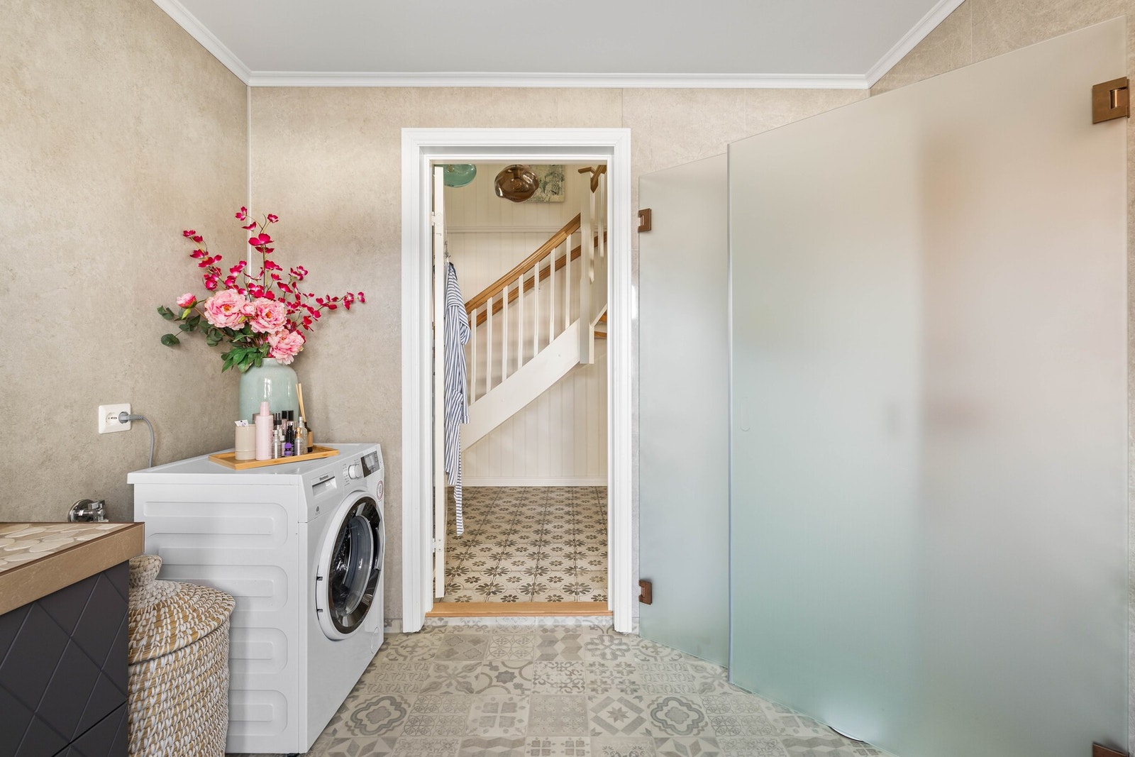 Badet er innredet med rund servant, flott baderomsinnredning, stort rundt speil, dusj med glassdører, vegghengt toalett samt opplegg for vaskemaskin. Galleribilde