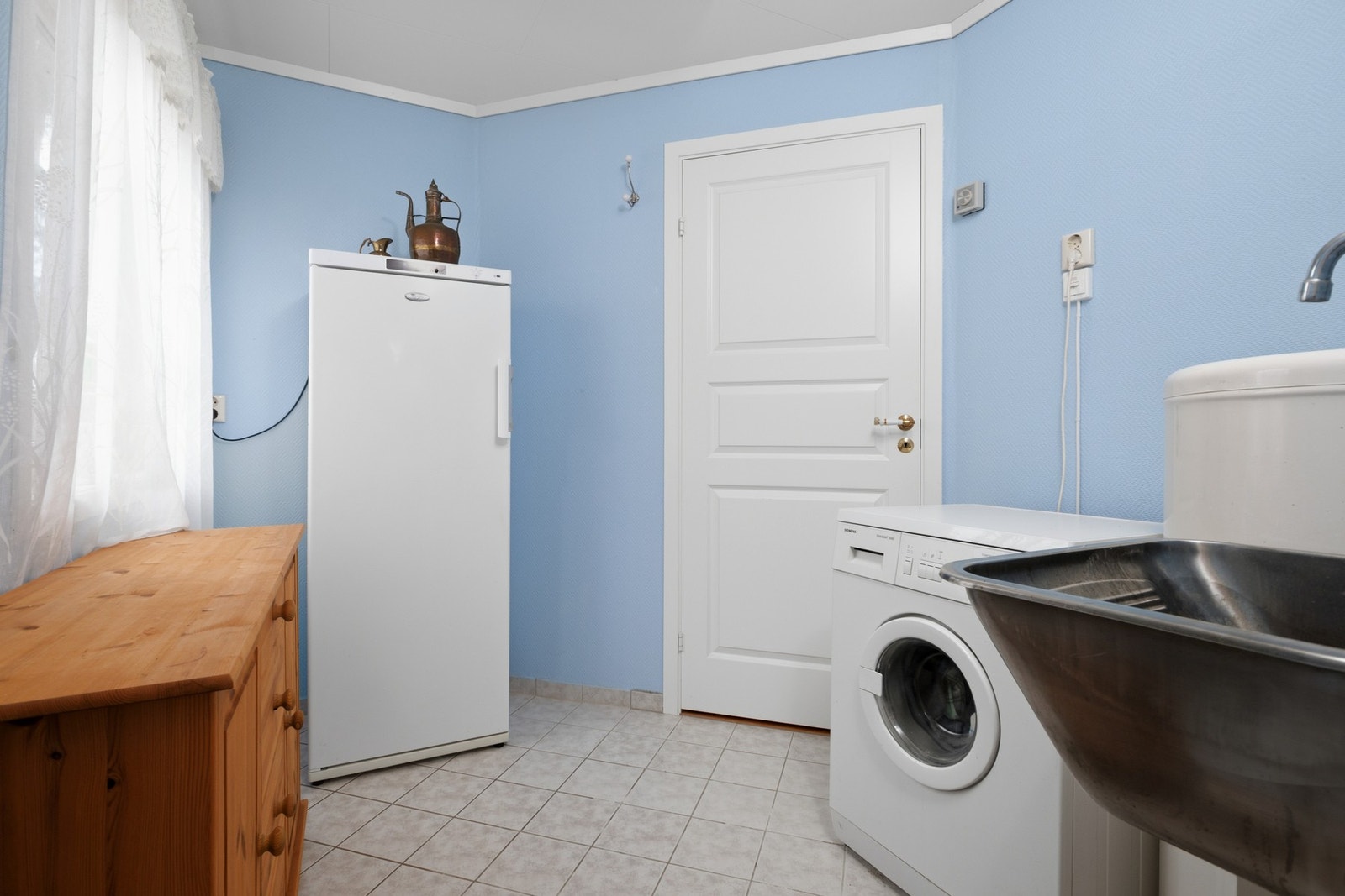 Eget vaskerom gir praktisk hverdagslogistikk med skyllekum i stål og opplegg for vaskemaskin. Også her er det varmekabler i gulv og flislagte overflater. Galleribilde